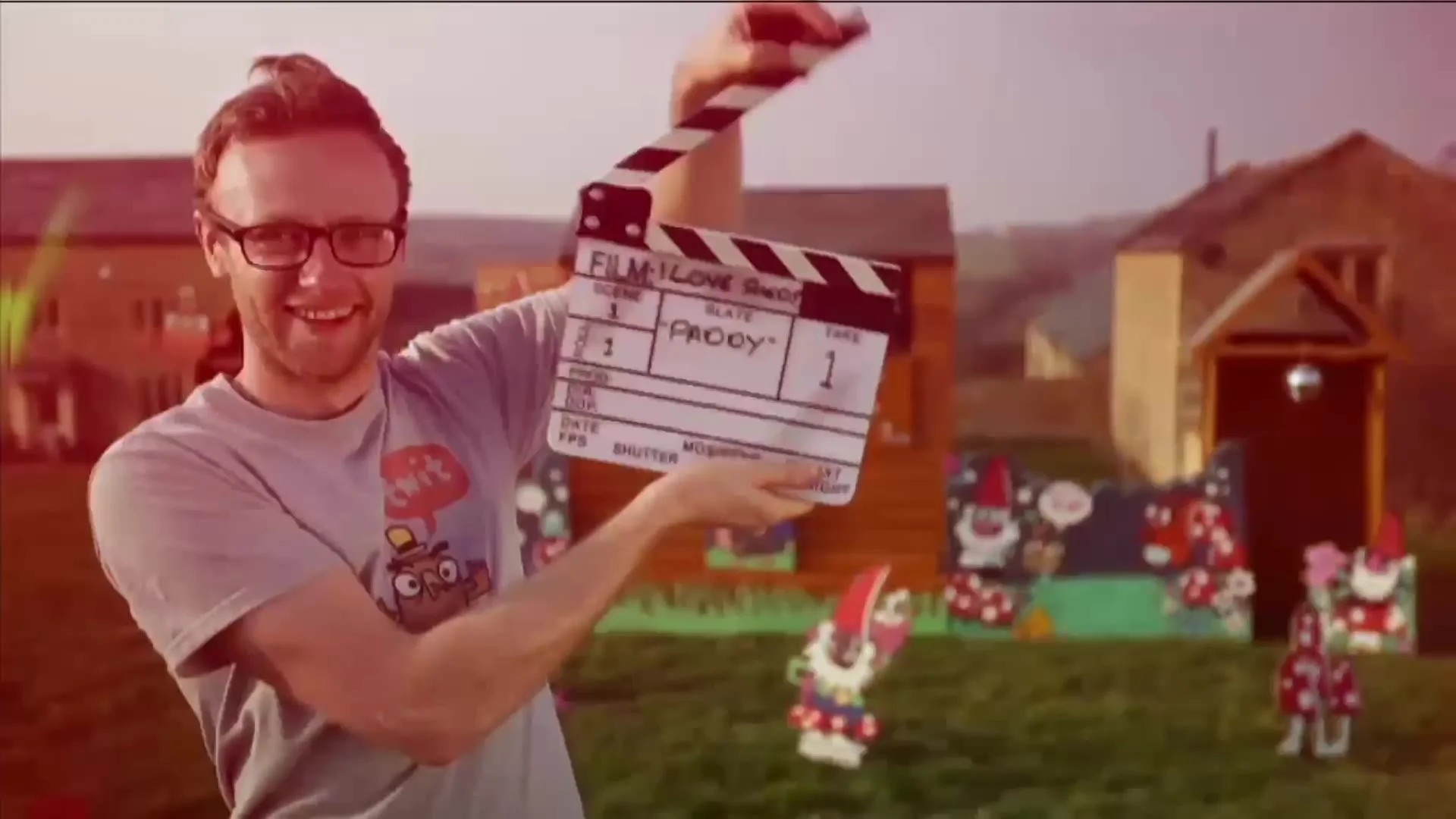 A contributor holding the clapperboard on set