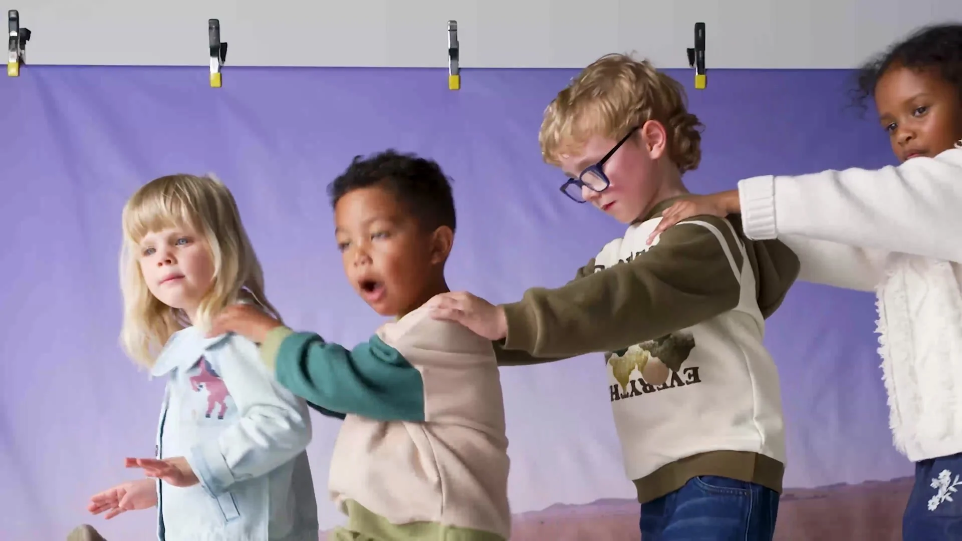 Children in Mothercare kidswear playing in front of a studio backdrop