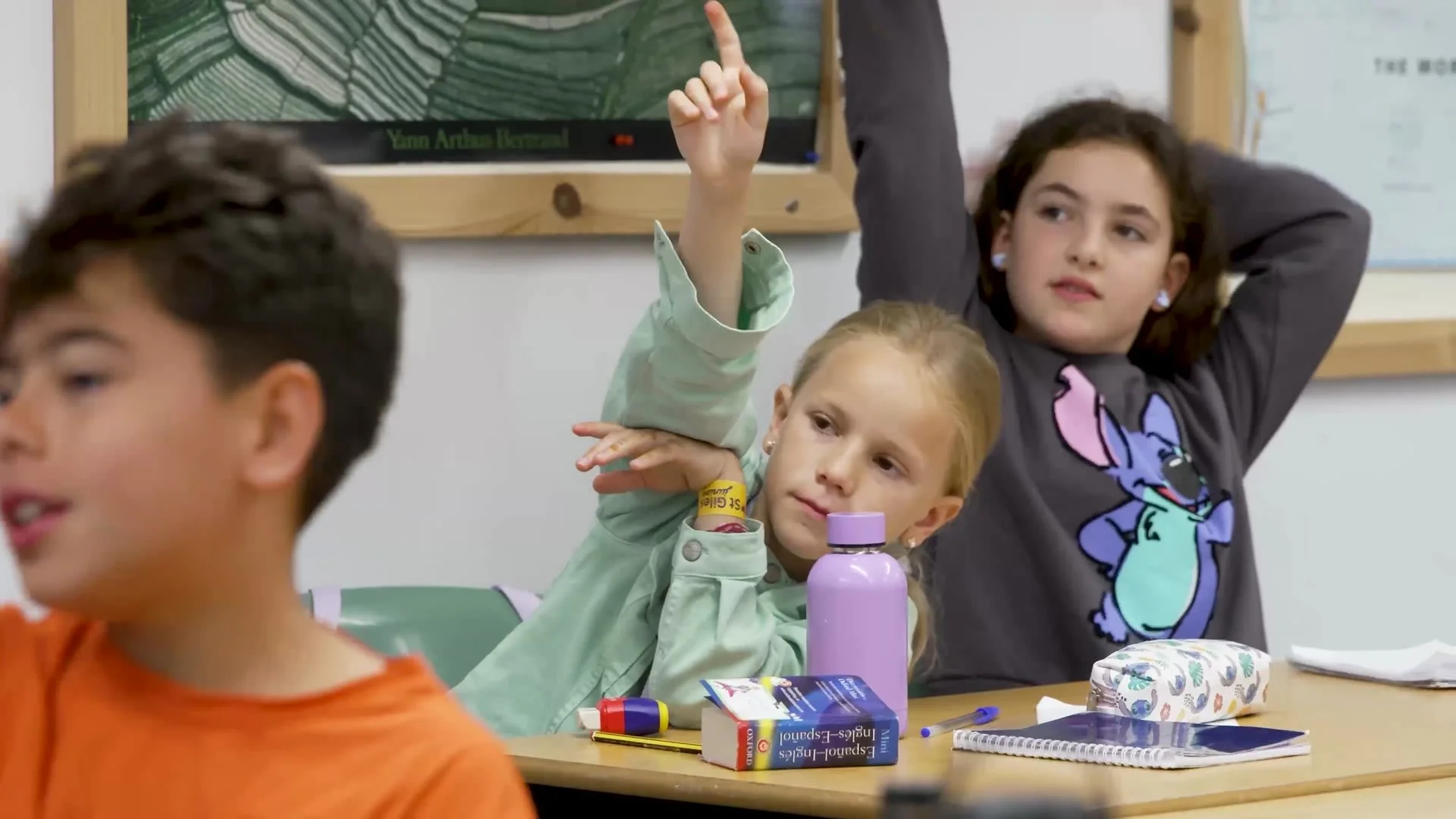Young learners putting their hands up in a St Giles class