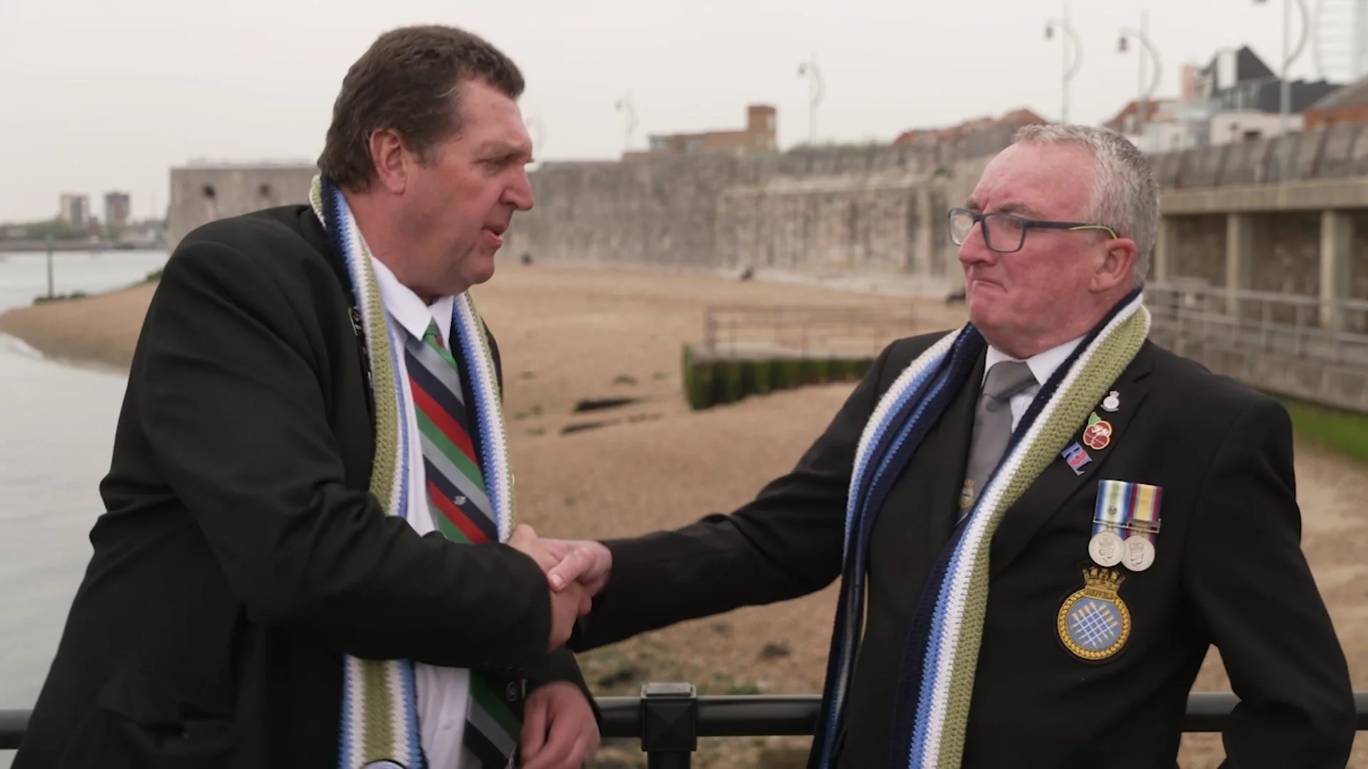 The two veterans shaking hands by the sea