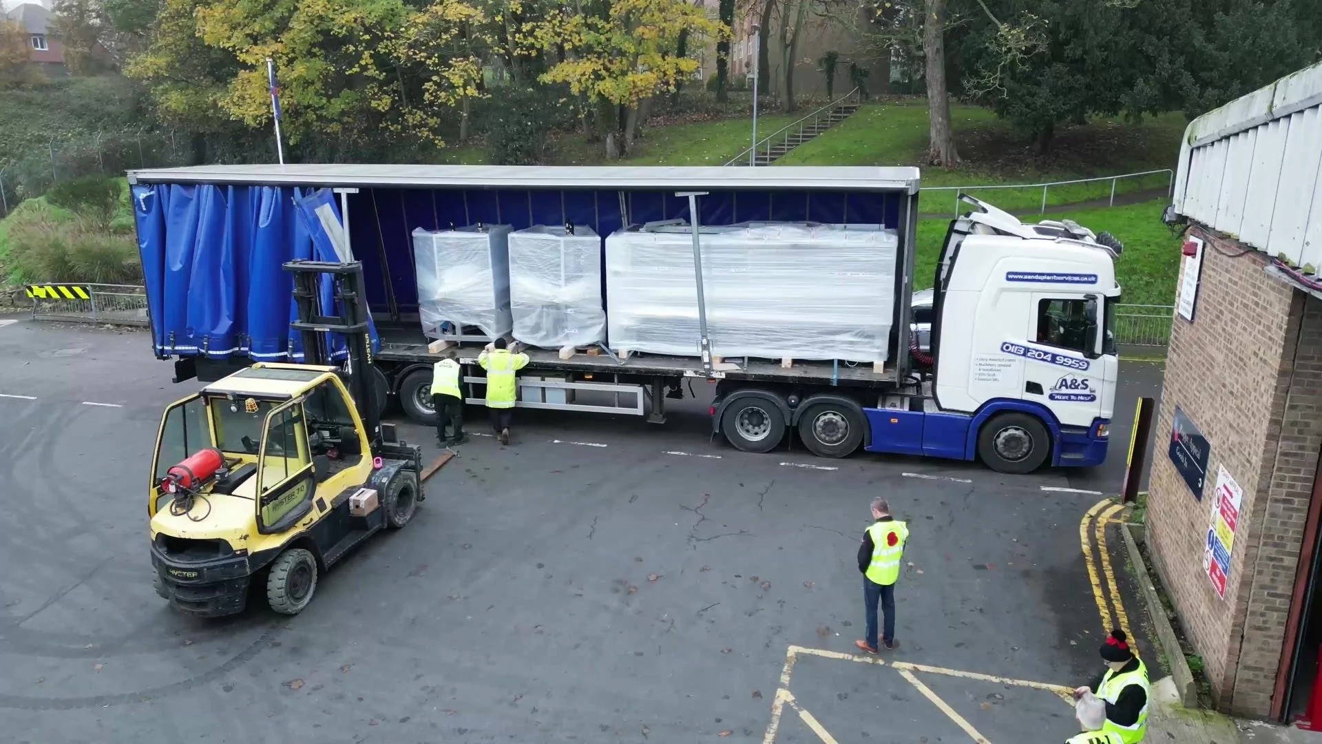 A forklift unloading a machine from the lorry