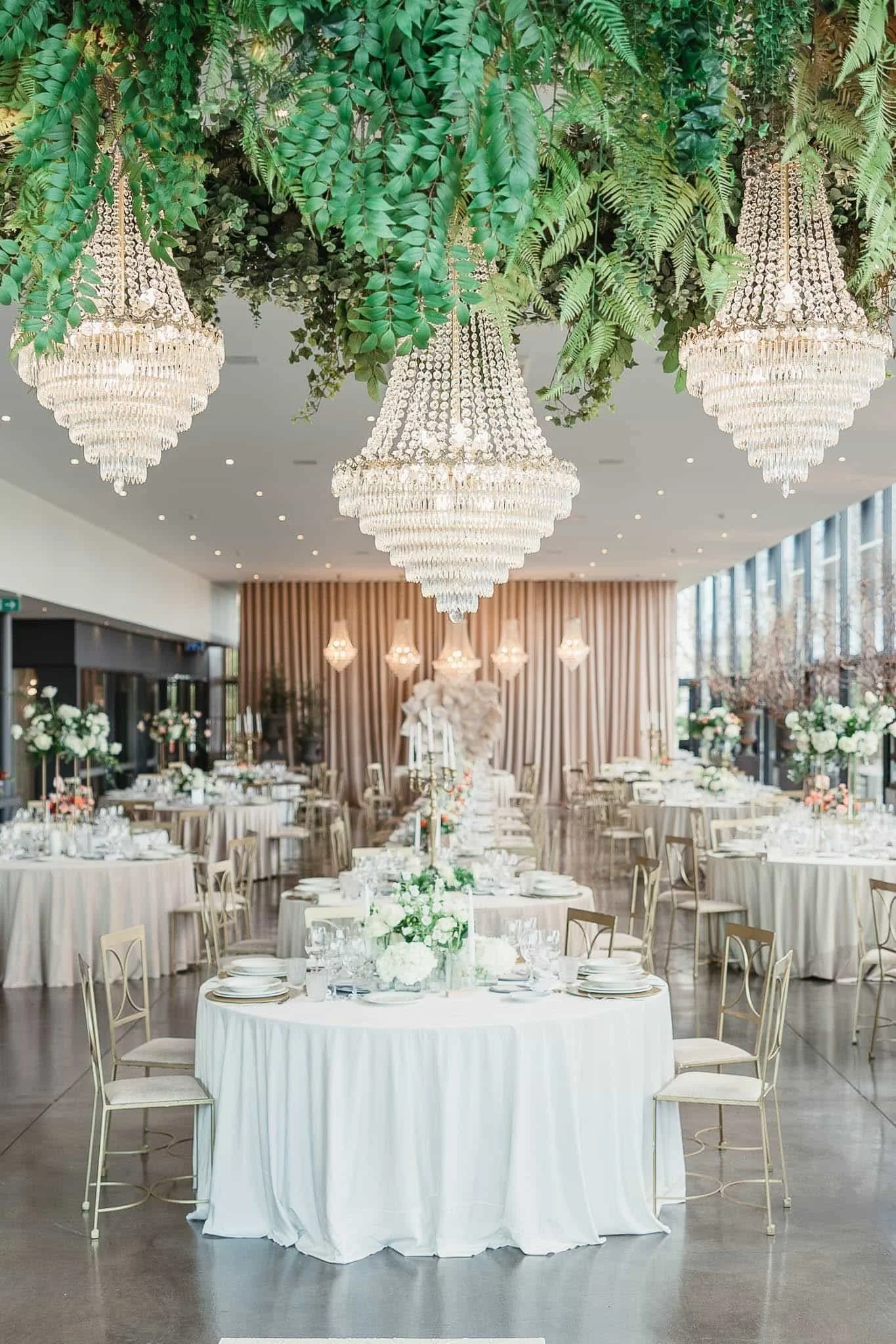 Destination Wedding Photographer Portugal -Elegant wedding reception in Quinta do Éden in Aveiro decorated with floral centerpieces, chandeliers, and draped curtains.