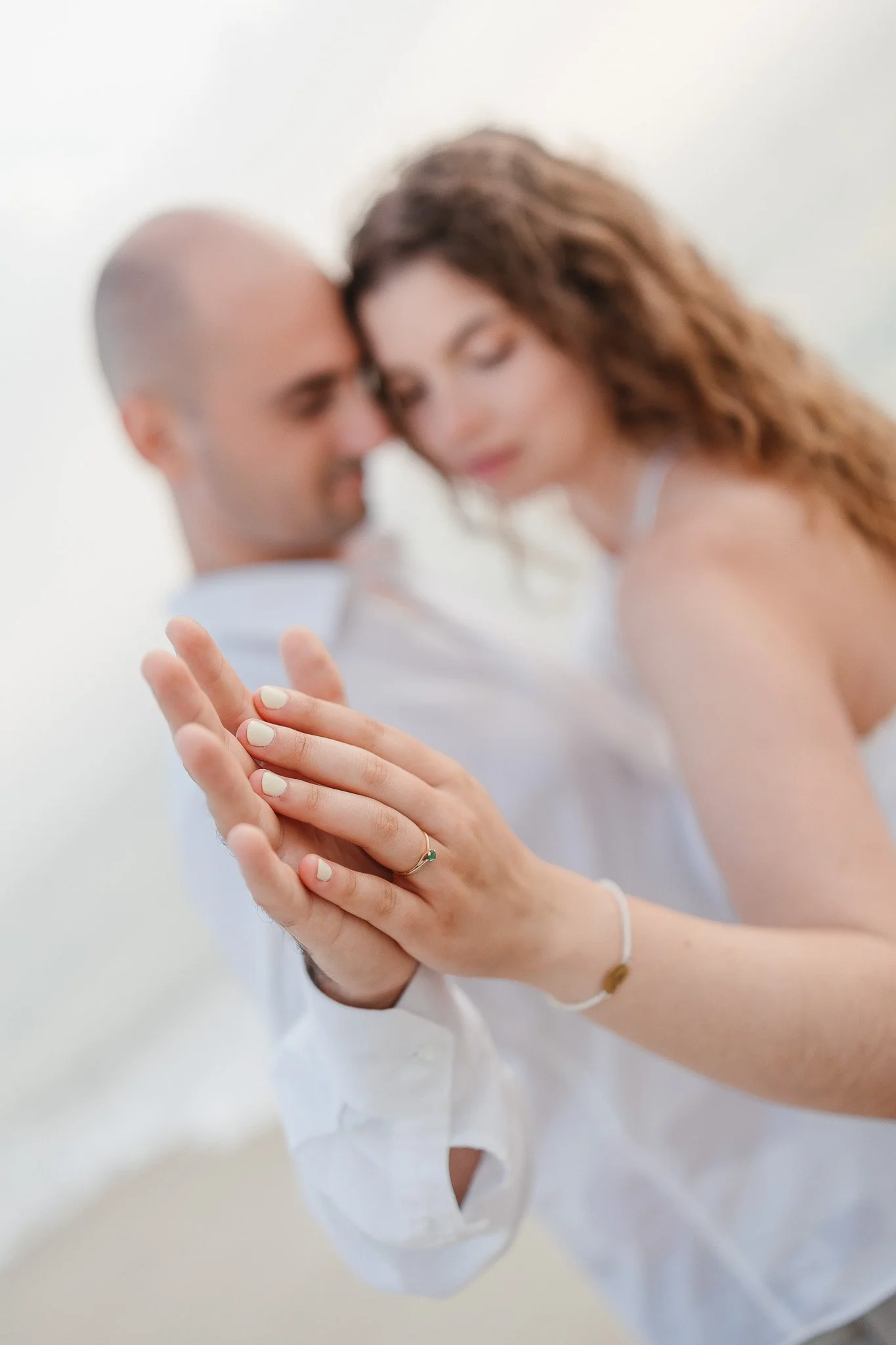 Engagement Session in Portugal: A couple is dancing closely, with the focus on their hands showing an engagement ring on the woman's finger.