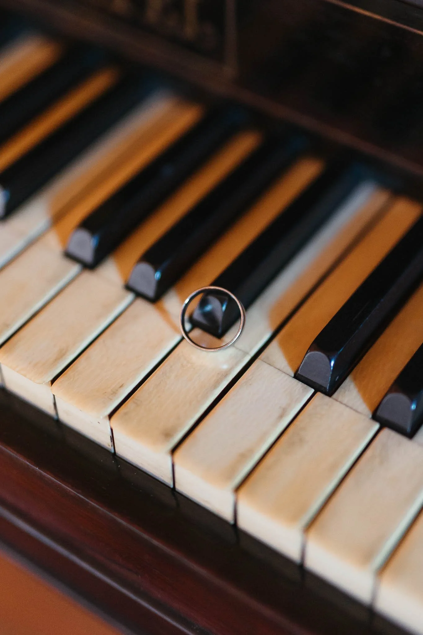 Close-up of piano keys with a ring resting on one, captured by Portugal Wedding Photography.