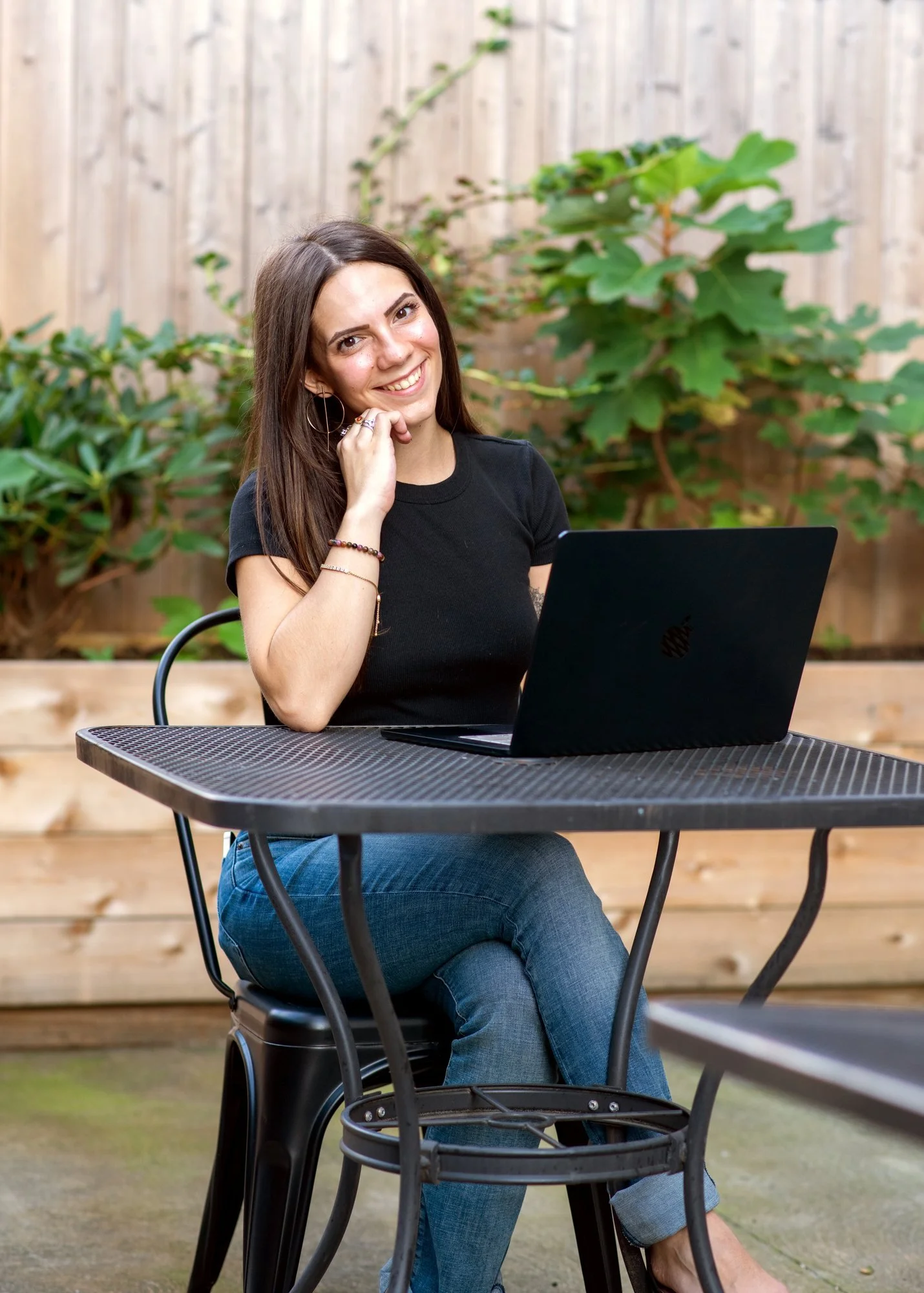 Sky working on her laptop at an outdoor table.