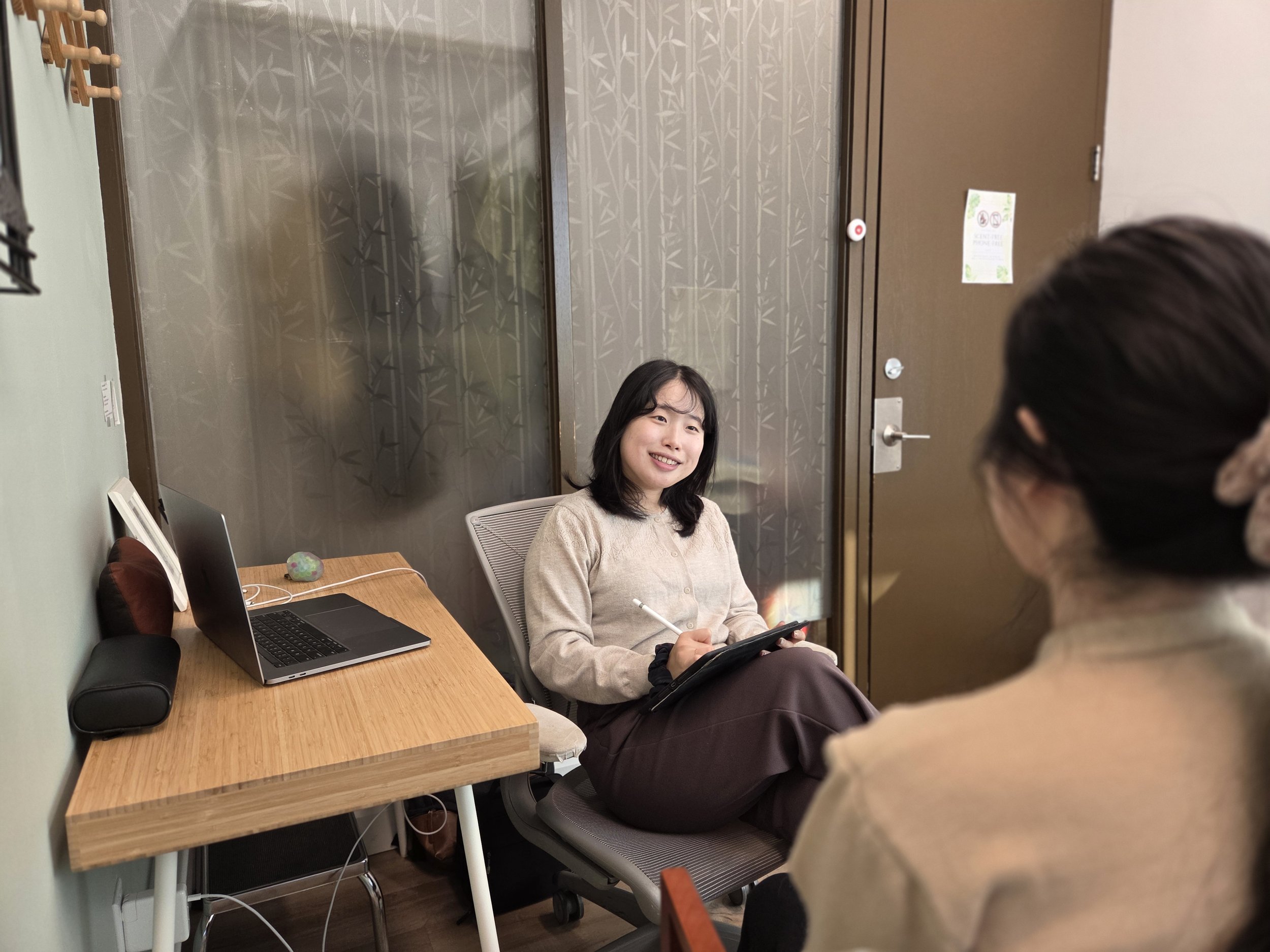 Two people holding hands on a white table, with a person also holding a cup of black coffee.