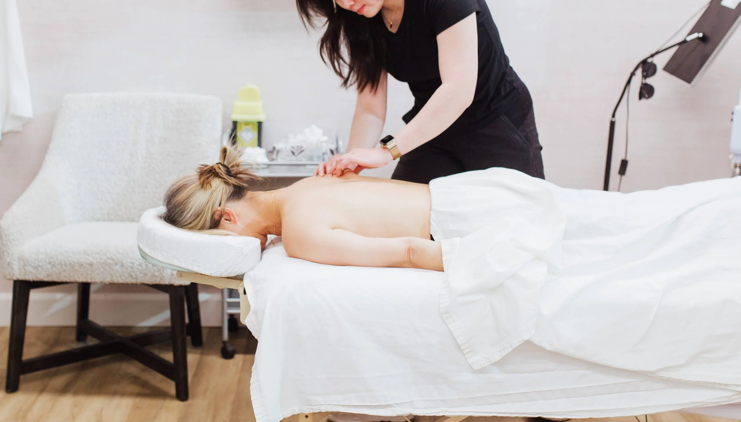Person receiving a massage on their back in a spa or therapy setting.