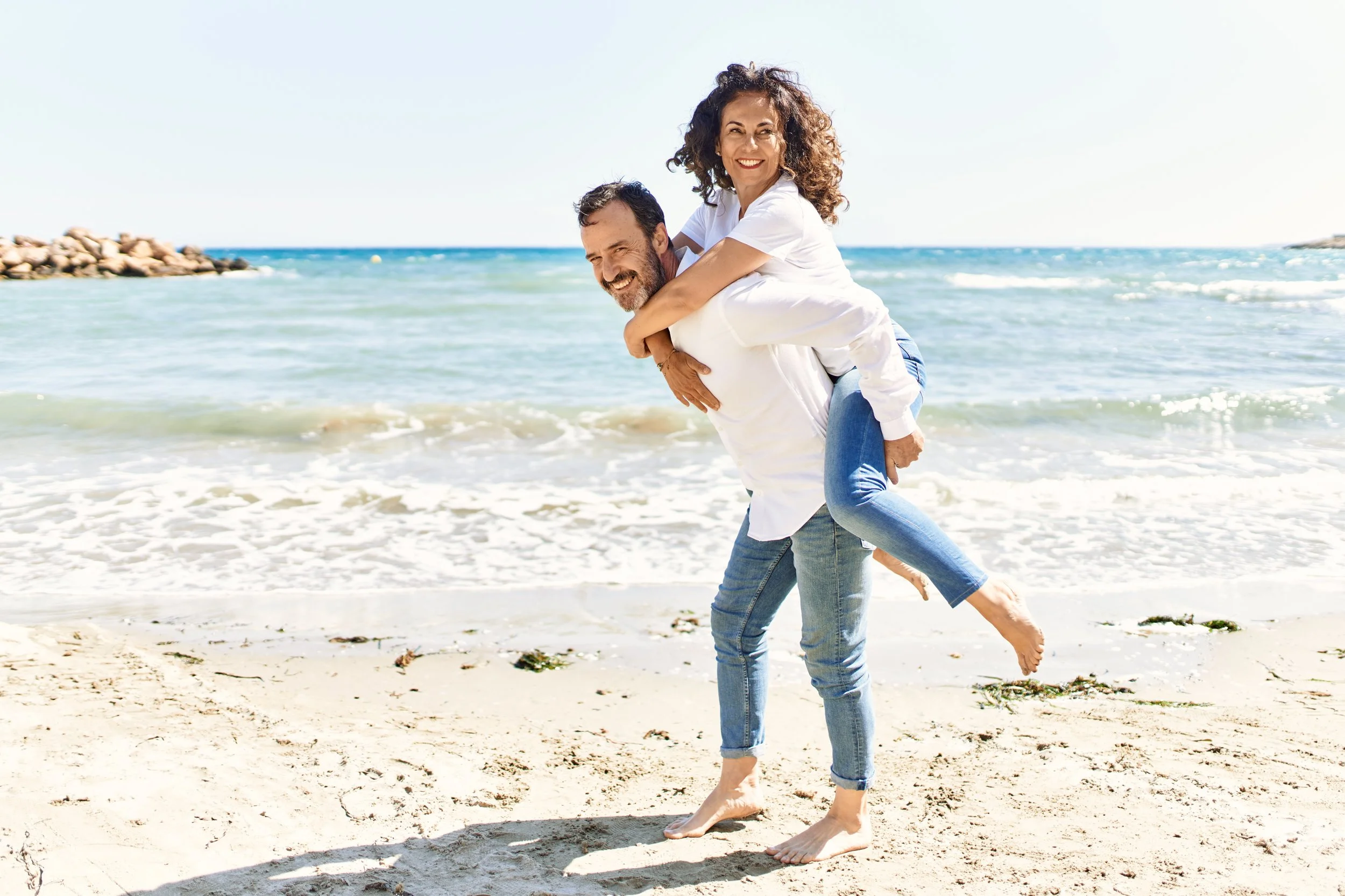 Couple enjoying a relaxing walk along the sandy beach in Indian Rocks Beach, Florida