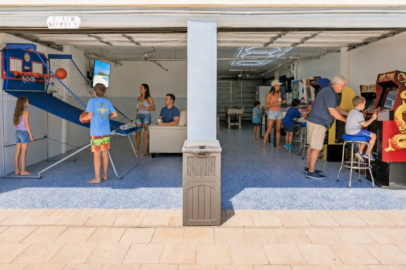 Families playing basketball and arcade games in the Condo Del Mar game room
