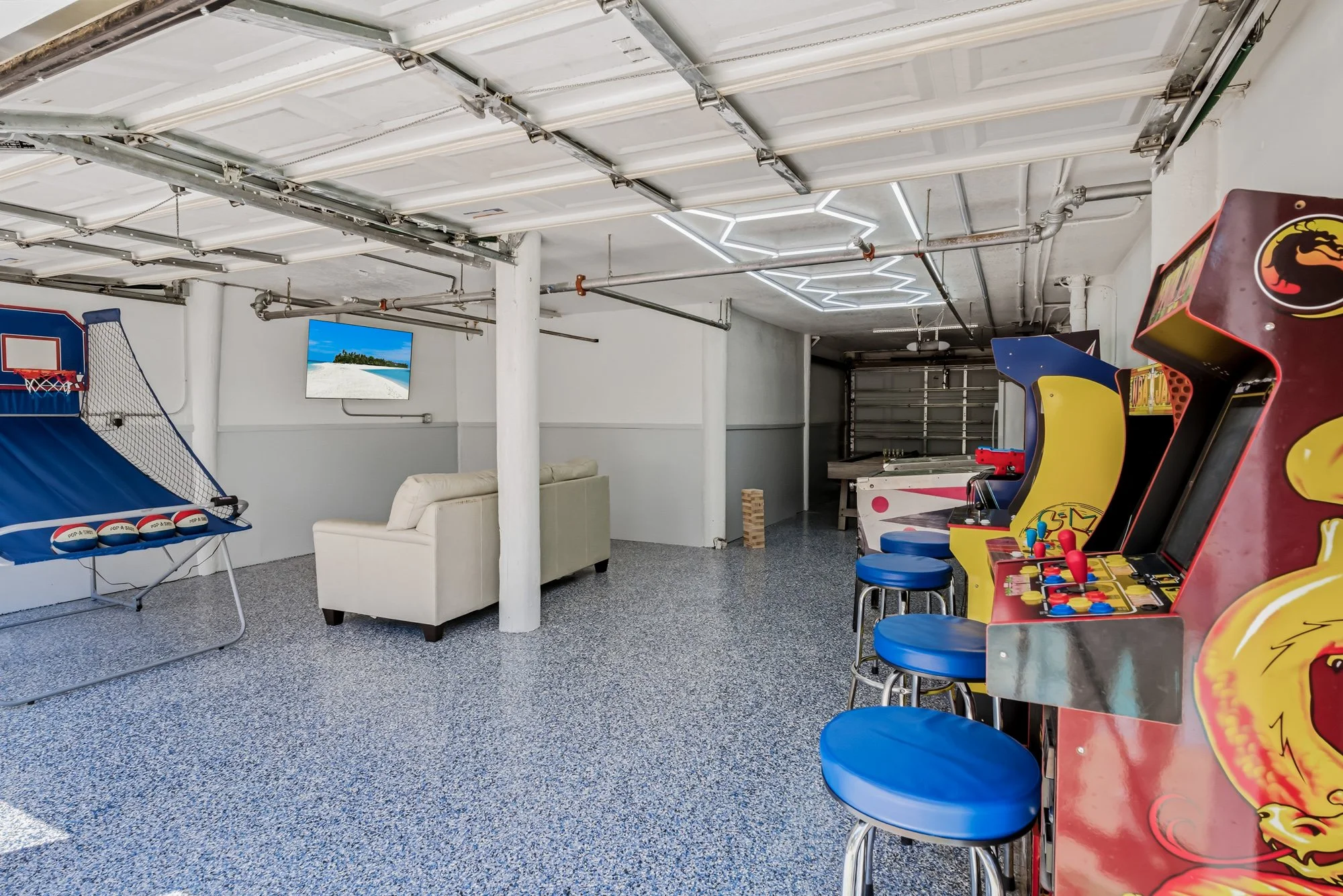 Game room showing basketball game and arcade games.