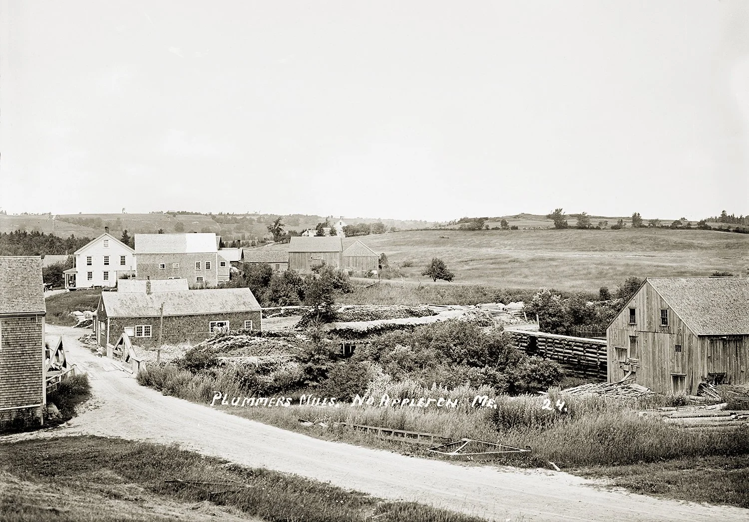 Plummers Mills, No. Appleton. Me
This location was also known as Smith’s Mills and Meservey’s Mills, among other names, depending upon the owner at the time. In the right foreground is the long lumber mill, fed by a penstock from the dam visible at i