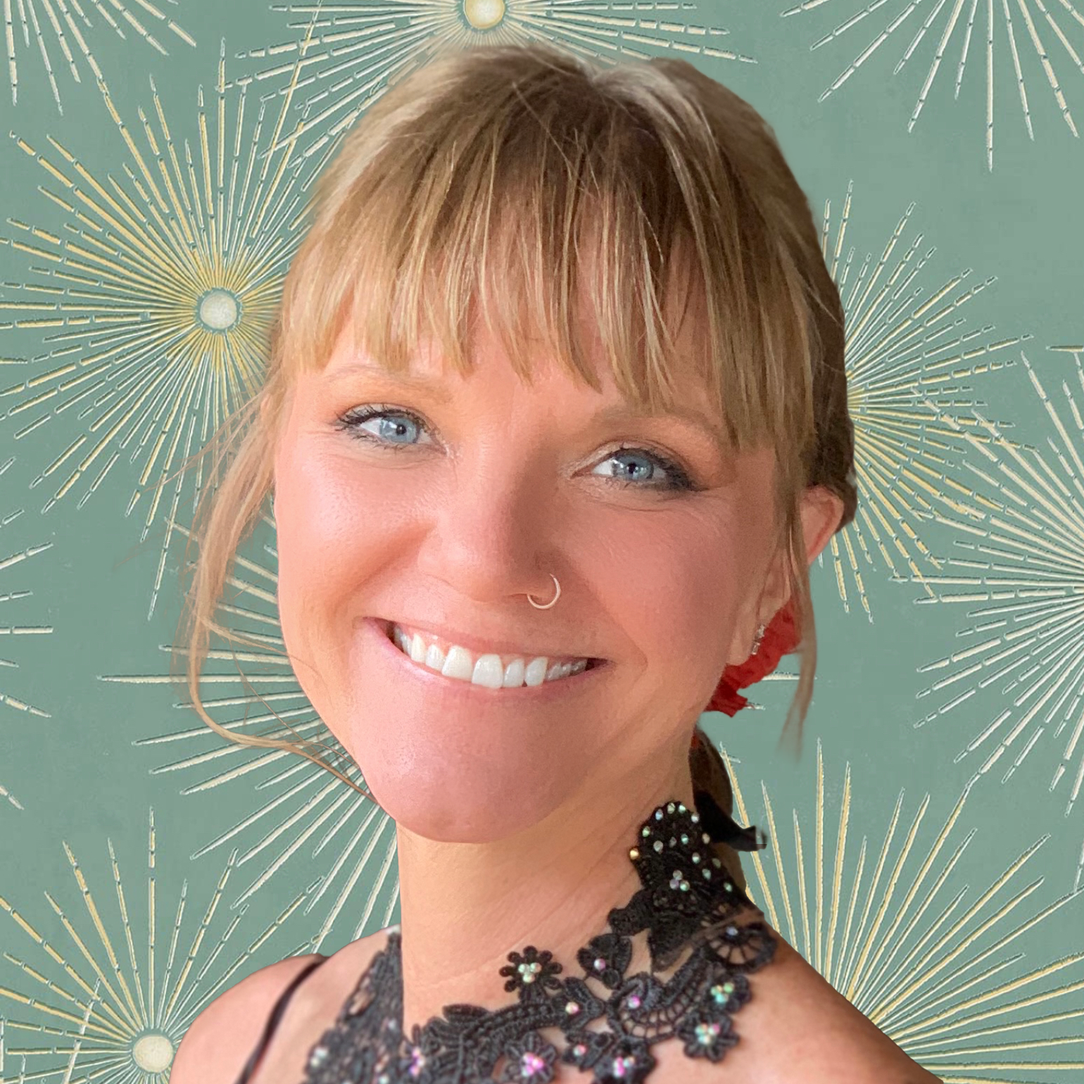 Close-up of a smiling woman with short blonde hair, blue eyes, a nose ring, and wearing earrings and a black lace top with rhinestones, against a green background with gold firework designs.
