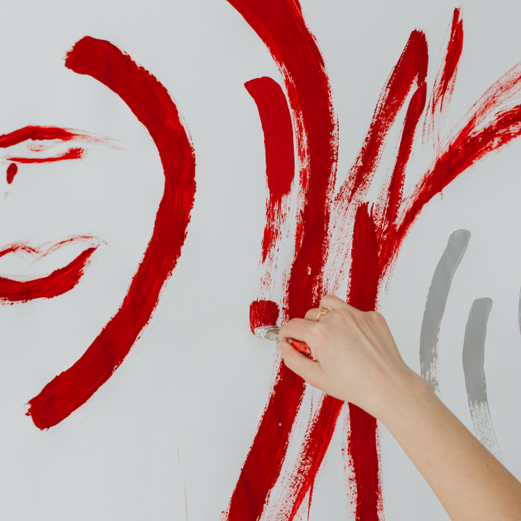 A person painting a large abstract mural in red tones on a white canva, expressing emotion, collaboration and creativity through through bold, expressive gestures.