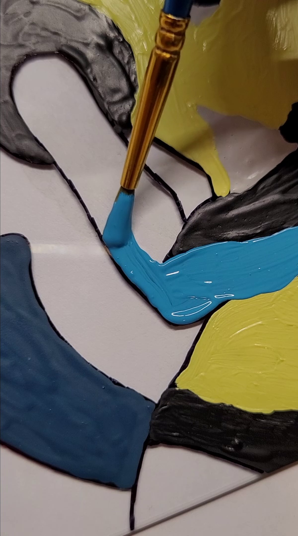 L'immagine mostra un quadro in fase di pittura con un pennello che applica vernice blu su una sezione.