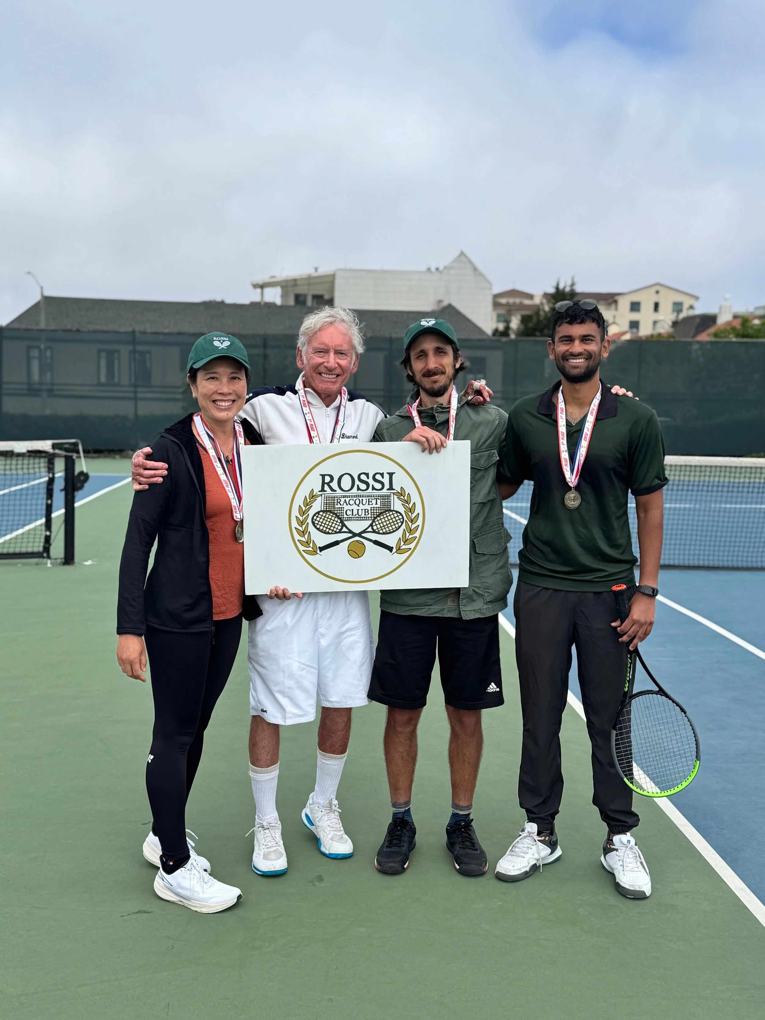 First inaugural Rossi Racquet Club Classic tournament winners wearing medals and holding rackets