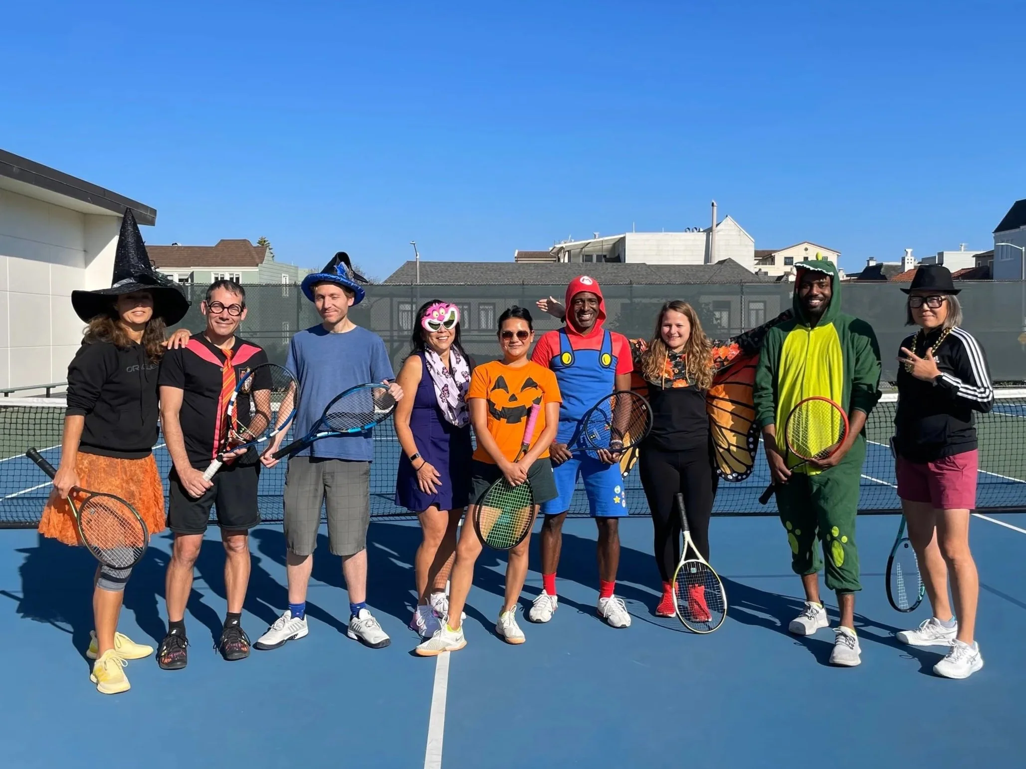 Rossi Racquet Club members in Halloween themed costumes standing on tennis court
