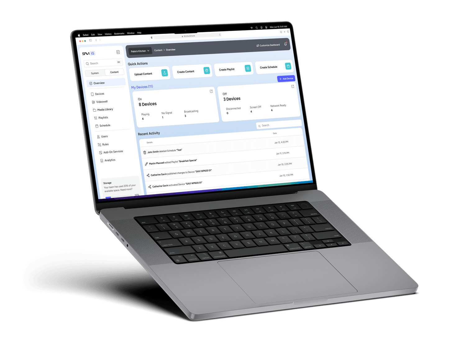 A laptop displaying SAVI Cloud dashboard interface with options for content management and device status, placed on a green background, casting a shadow.