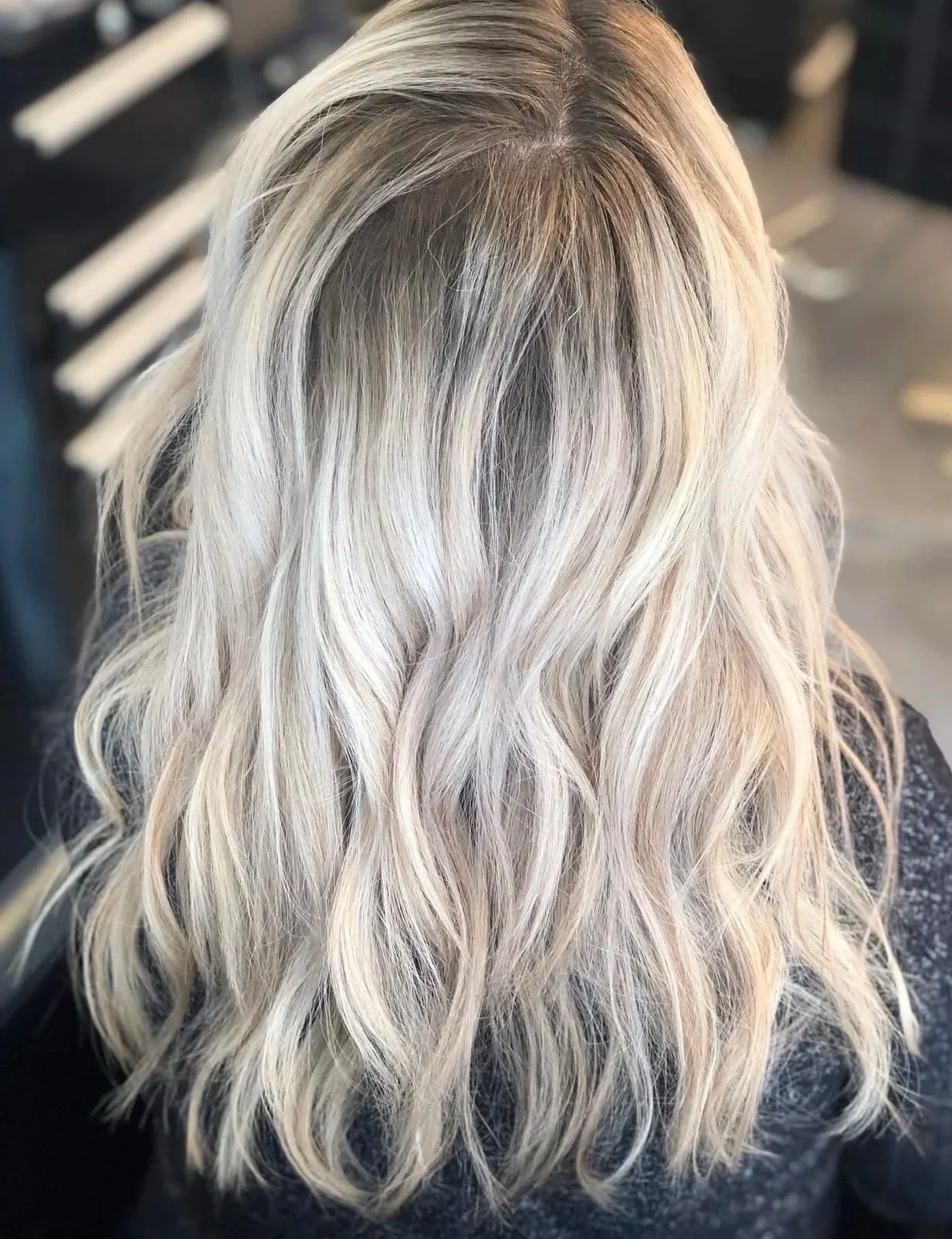 Back view of a woman with long, wavy, platinum blonde hair.