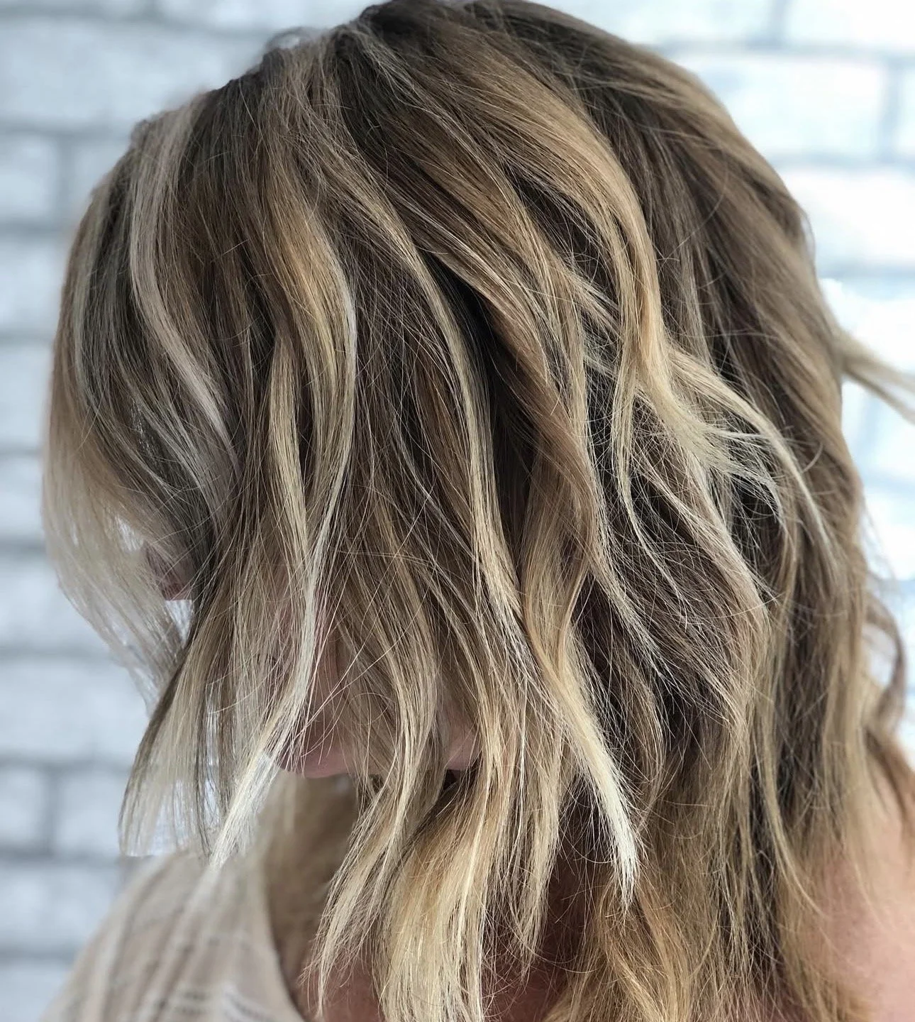 Close-up of wavy blonde hair with light highlights.