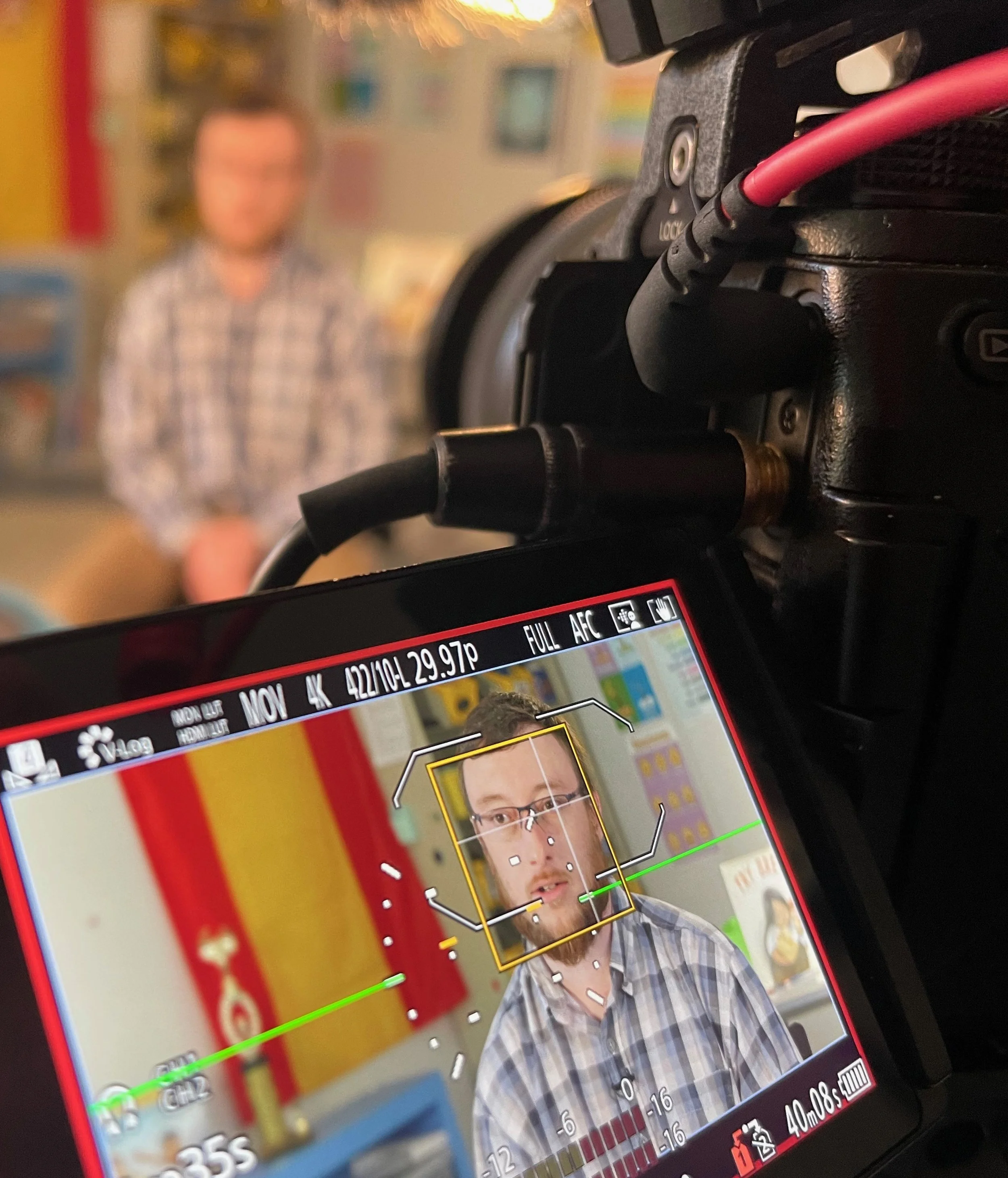 Professional video camera monitor showing interview filming setup