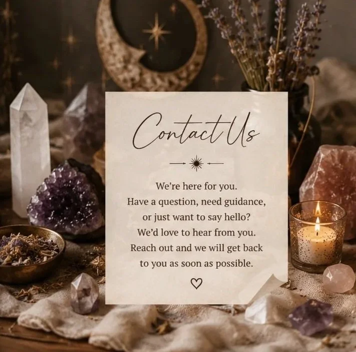 A contact us sign with a message, surrounded by crystals, a lit candle, and dried flowers, with a dark, celestial-themed background.