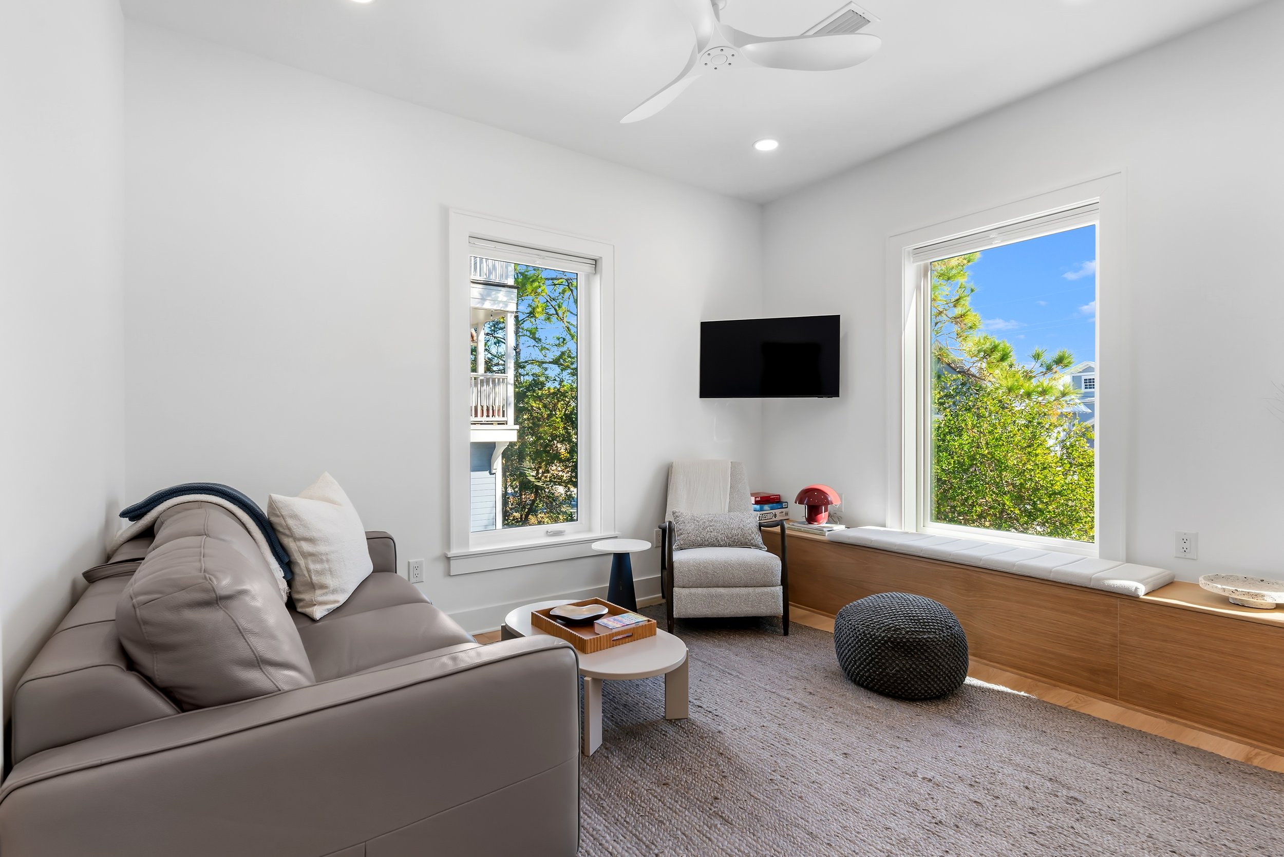 Light-filled guest house living space with modern finishes and comfortable seating, ideal for a 30A getaway.