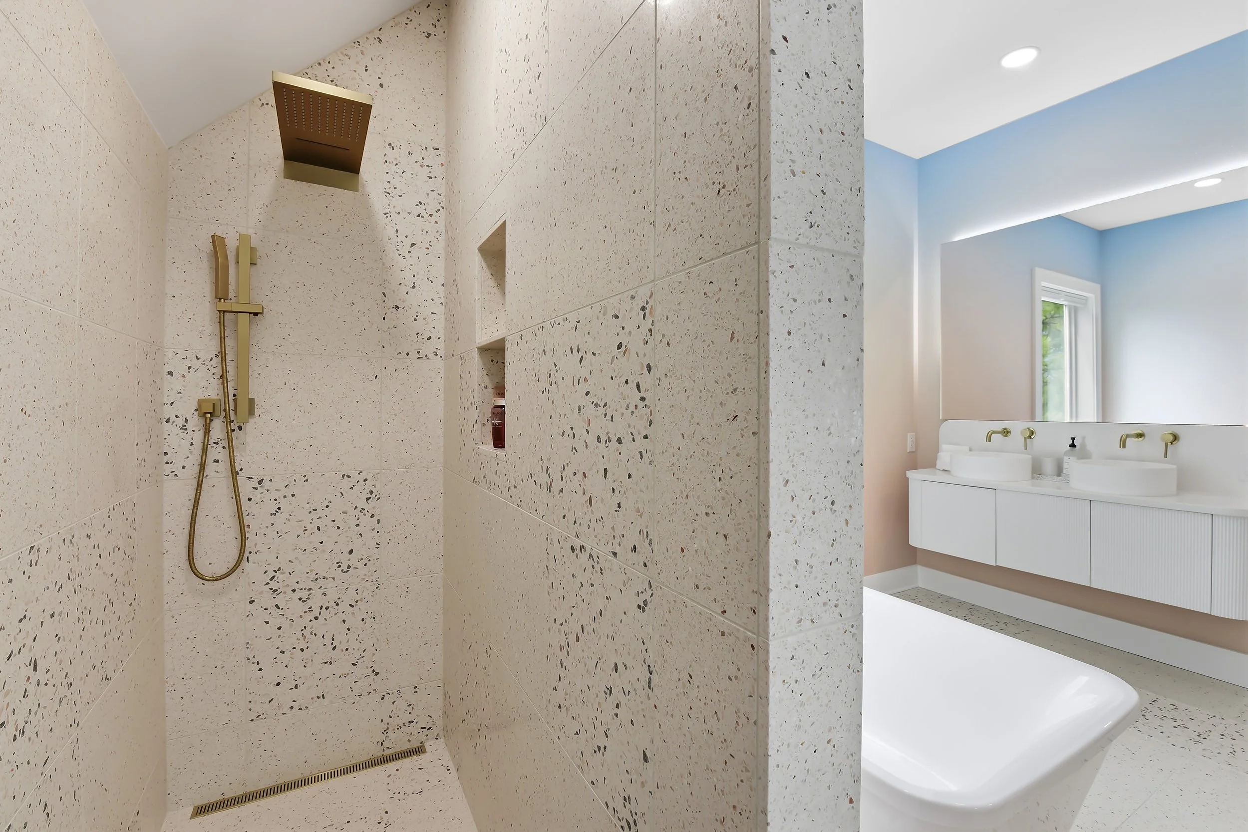 Ensuite bathroom featuring custom shower, terrazzo tile, and modern ombre wallpaper.