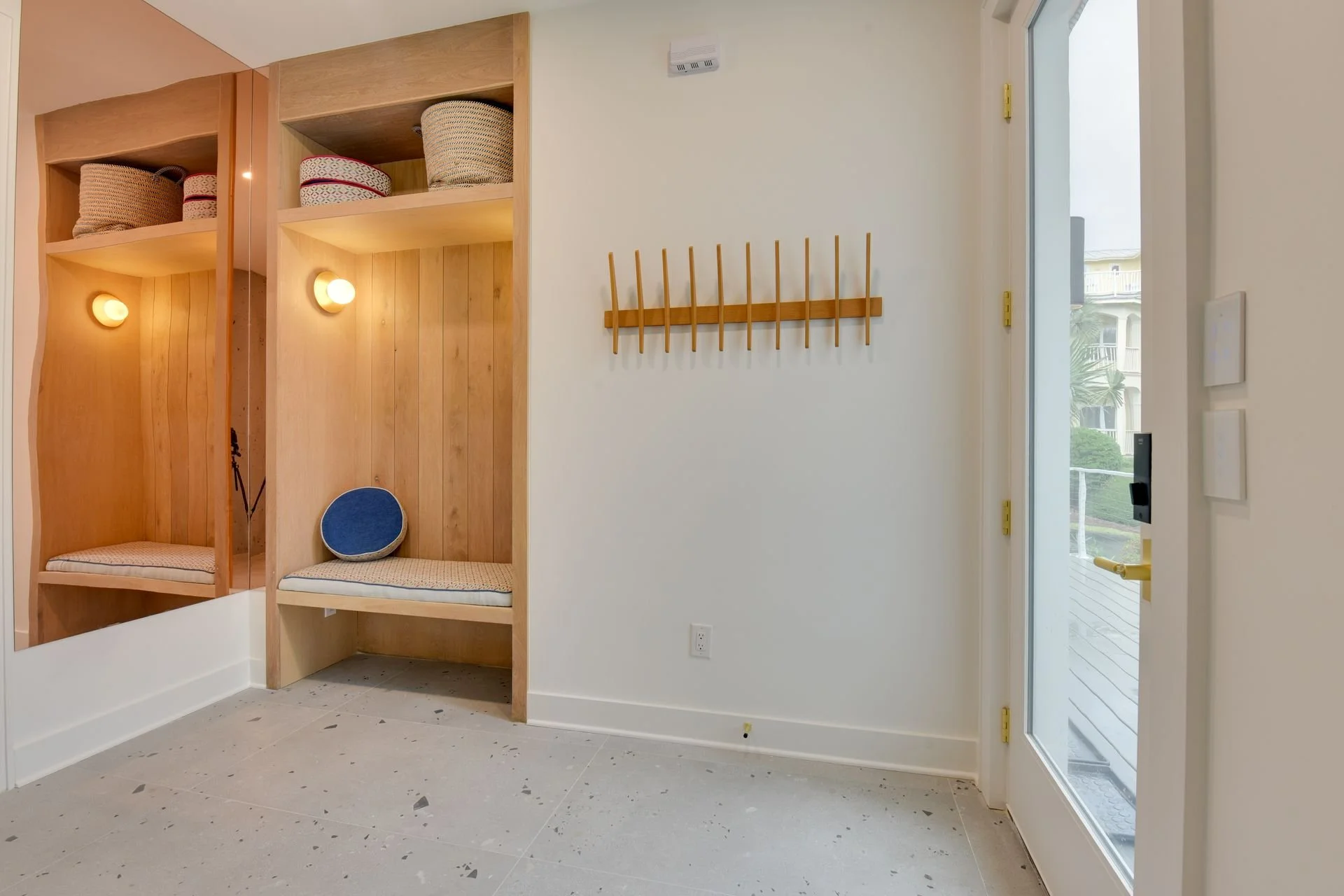 Interior entry “sand room” with built-in bench and wall hooks, offering a practical place to drop shoes, beach bags, and towels after a day on 30A.
