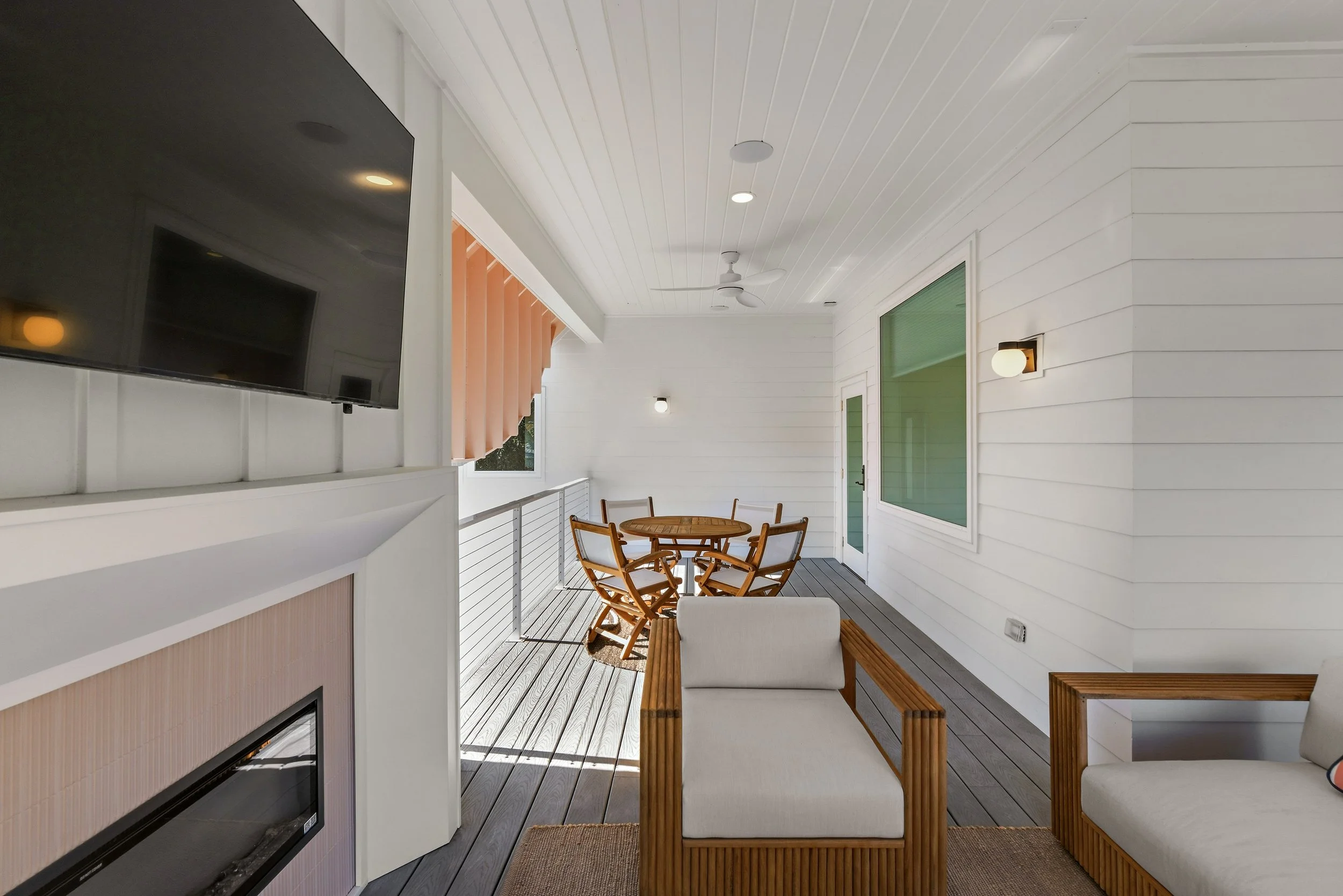 Covered upper-level porch featuring a cozy outdoor fireplace and lounge seating at Kate’s House on 30A. A private retreat for morning coffee, evening gatherings, and year-round outdoor living near Santa Rosa Beach.