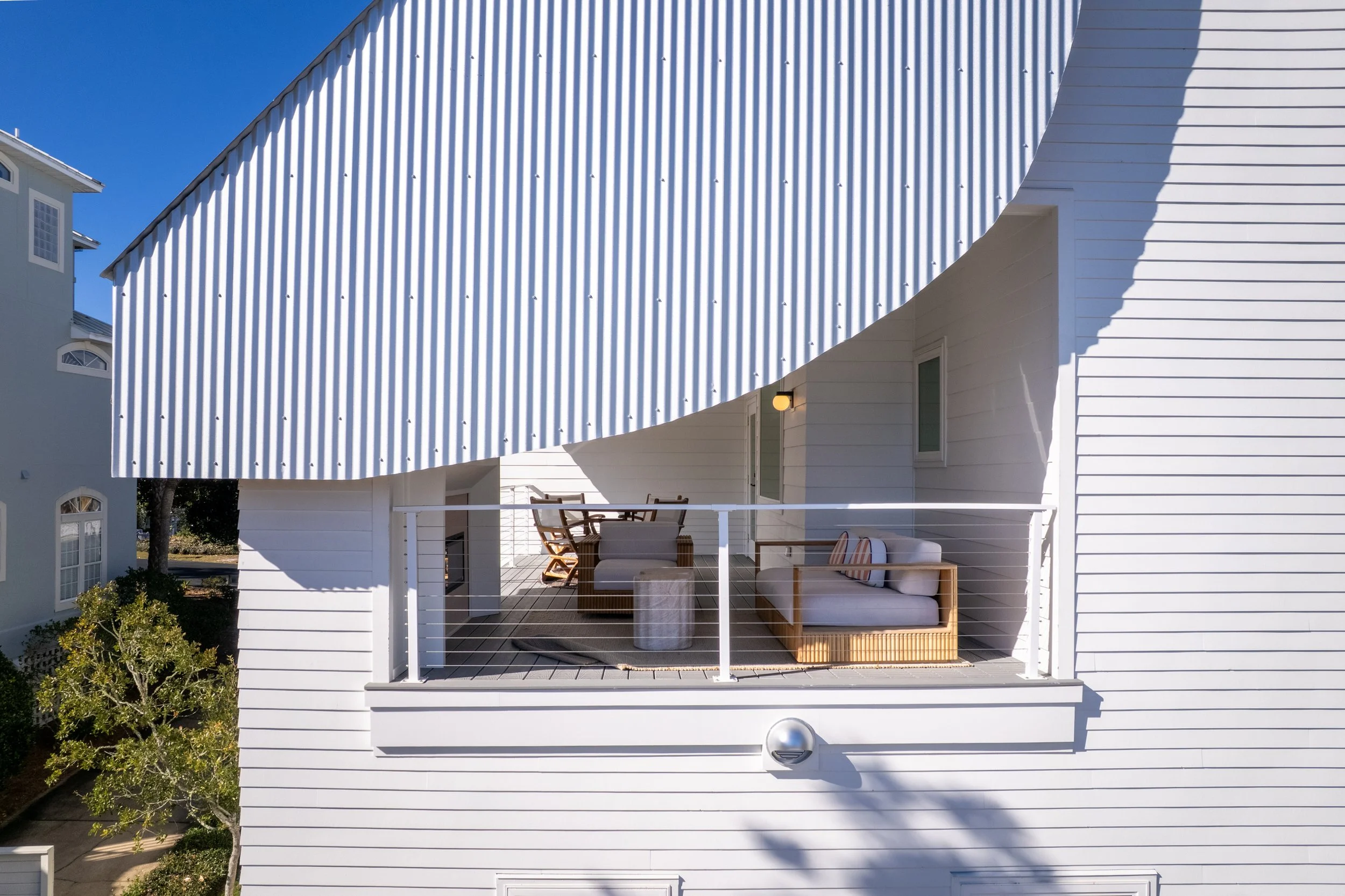 Upper-level private porch with outdoor dining at Kate’s House on 30A, offering a shaded setting for al fresco meals just steps from the beach. Designed for relaxed coastal living with custom detailing and architectural character.