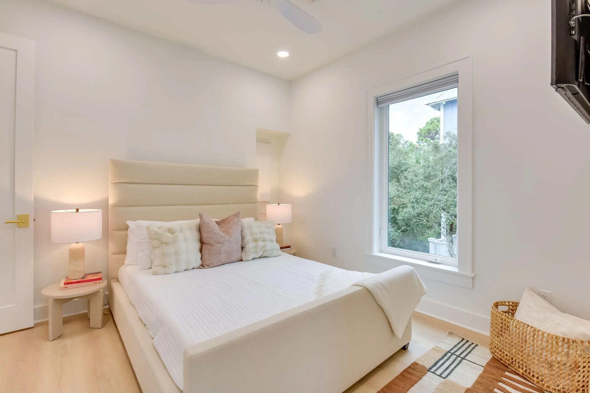 Serene guest house bedroom with plush bedding, modern furnishings, and natural light near Florida’s 30A.