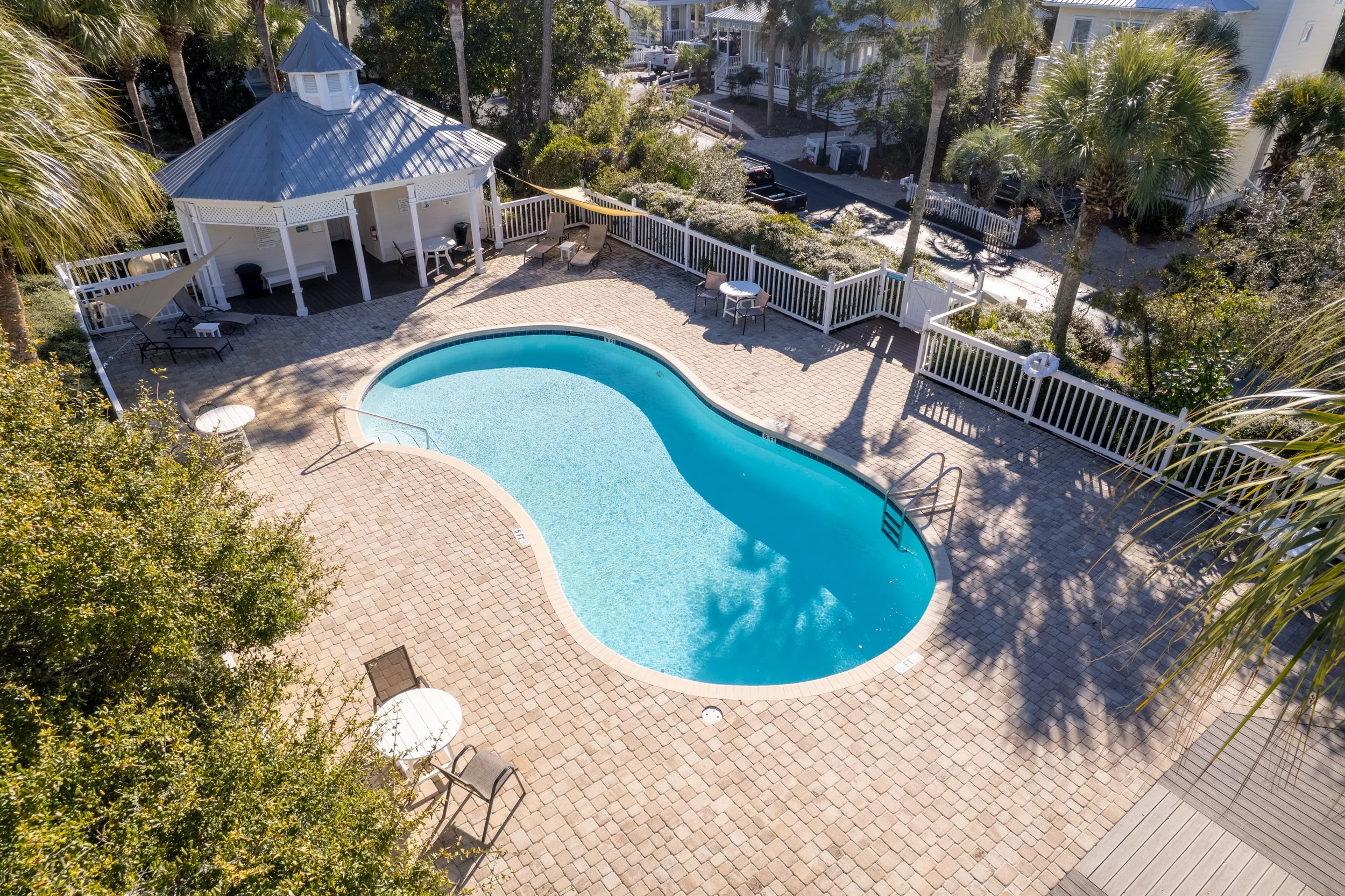Access to a shared neighborhood pool surrounded by palms, just steps from the main house.