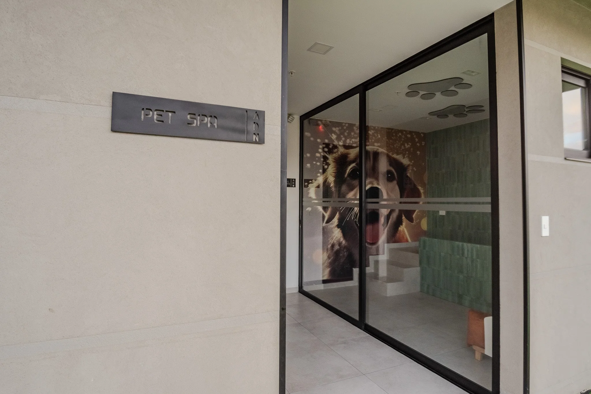 View of a pet spa entrance with a glass door featuring a large dog’s face poster inside.