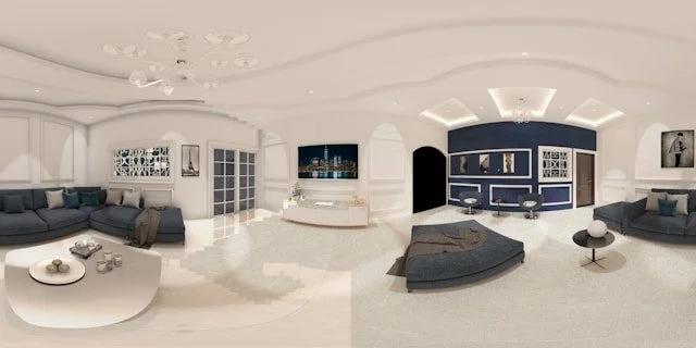 Modern living room with white walls and ceiling, dark gray sofas, a white coffee table, and built-in shelving. A large flat-screen TV is mounted on the wall, and decorative elements are displayed throughout the room.