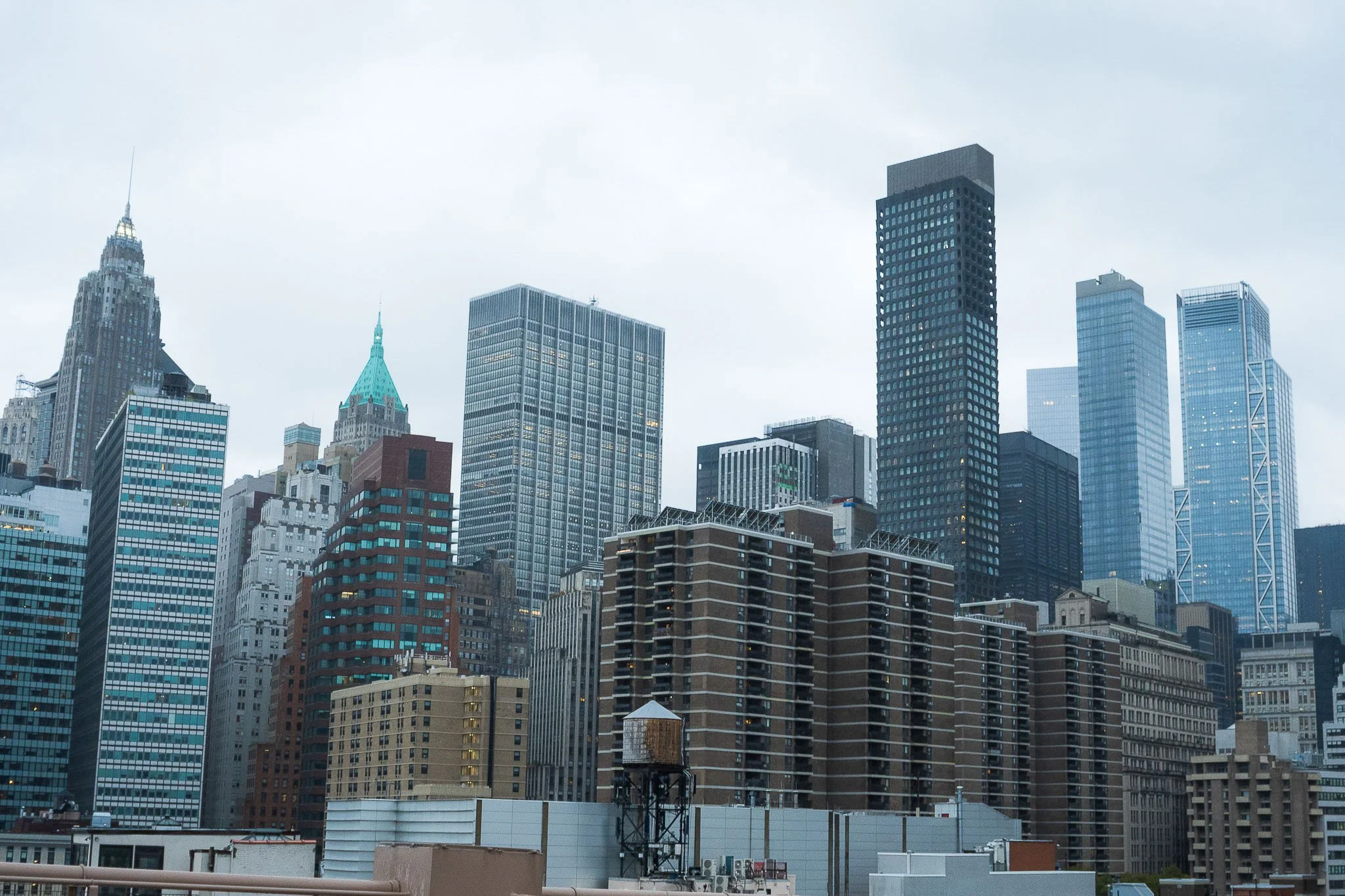 City skyline with tall skyscrapers under cloudy sky in New York City.
