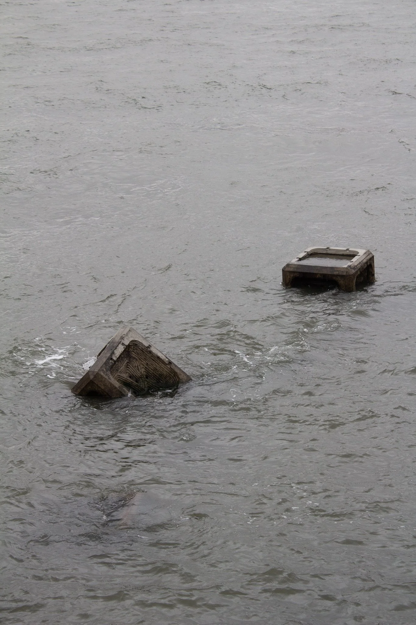 Two submerged wooden structures or objects floating in a body of water.