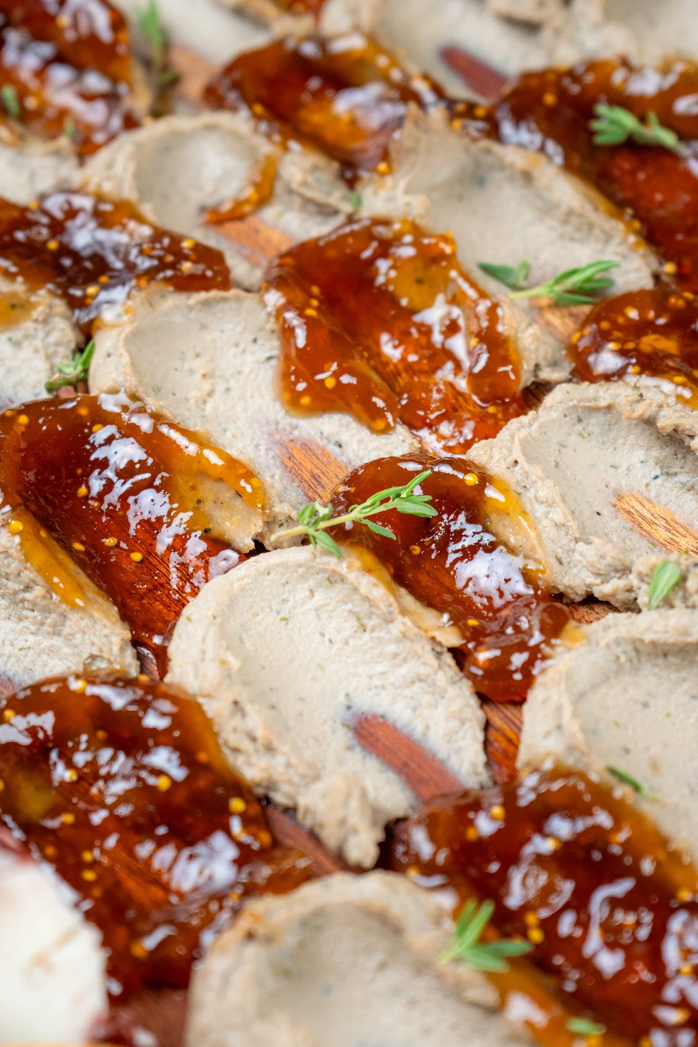 Close-up of cooked stuffed pasta shells topped with tomato sauce, garnished with sprigs of herbs.
