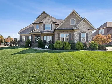 Front view of a large, two-story house with a well-maintained lawn and landscaping.