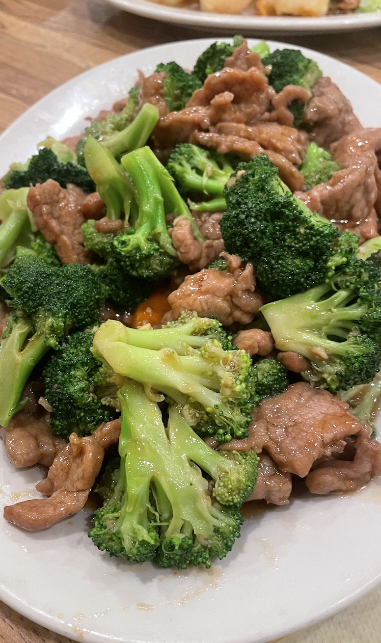 Sliced flank steak with fresh broccoli florets in a savory brown sauce.