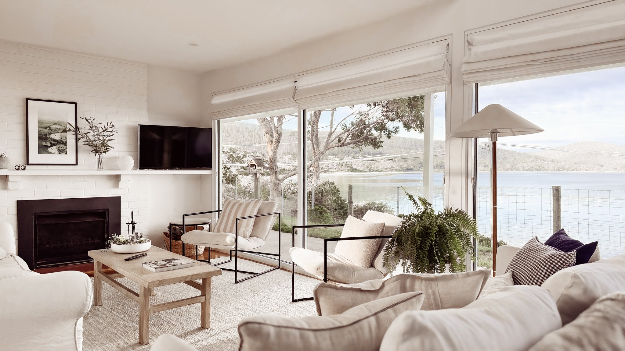 Comfortable living with couches, relaxing armchairs, a fireplace, large windows with direct views of the beach