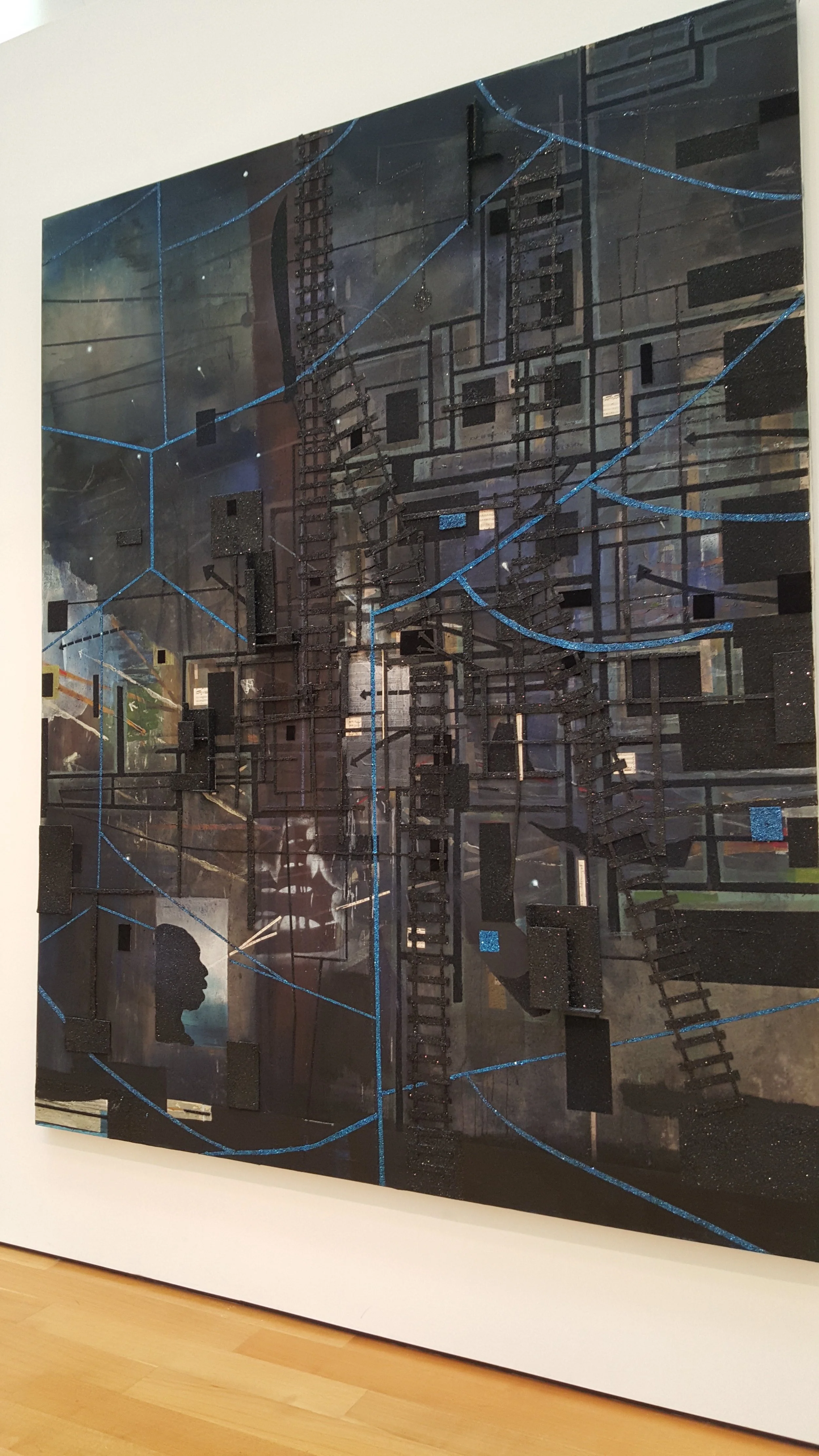 Artistic map with black and dark blue tones, featuring interconnected lines and small blocks, with some sections highlighted in blue.