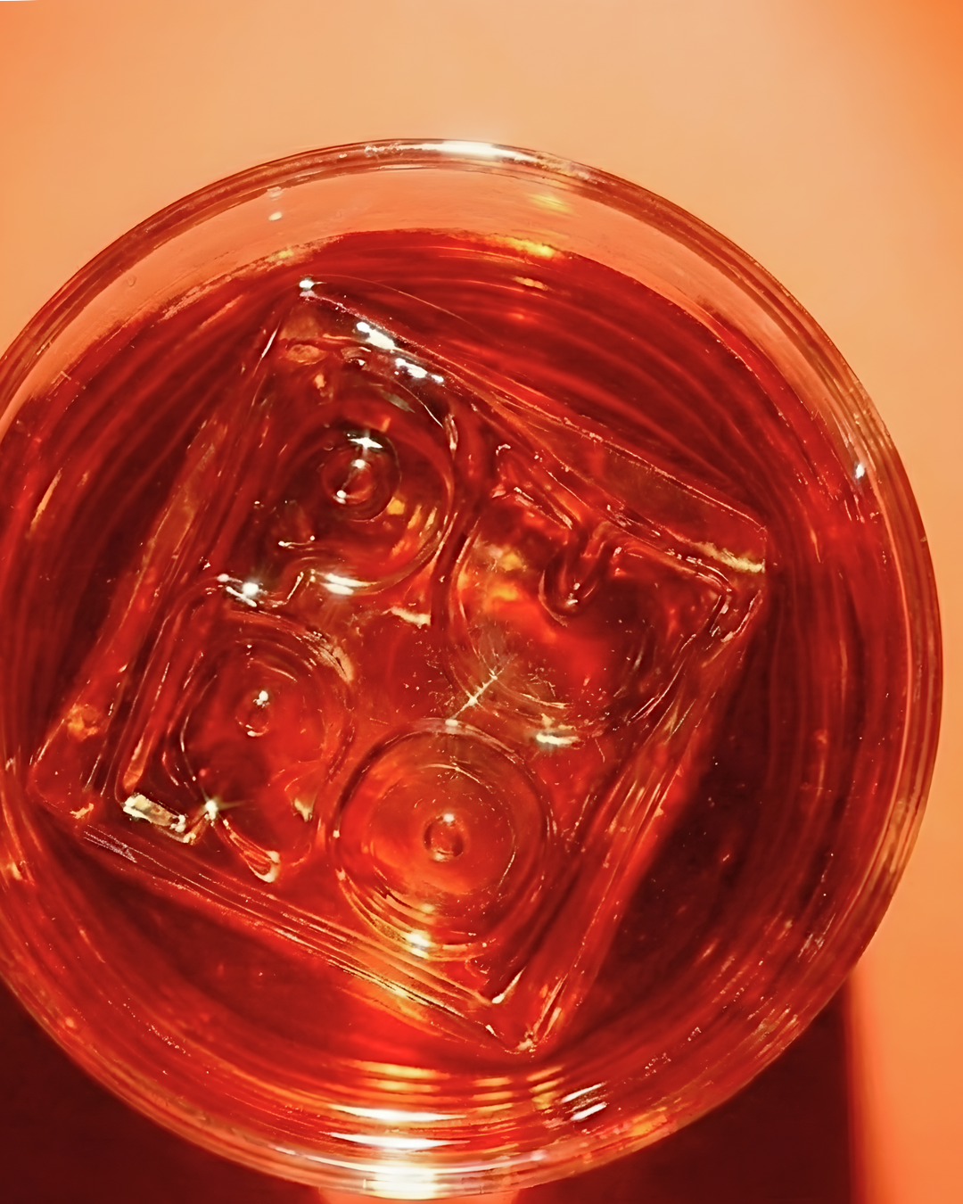 Close-up of a glass with ice cubes filled with a red-colored beverage.