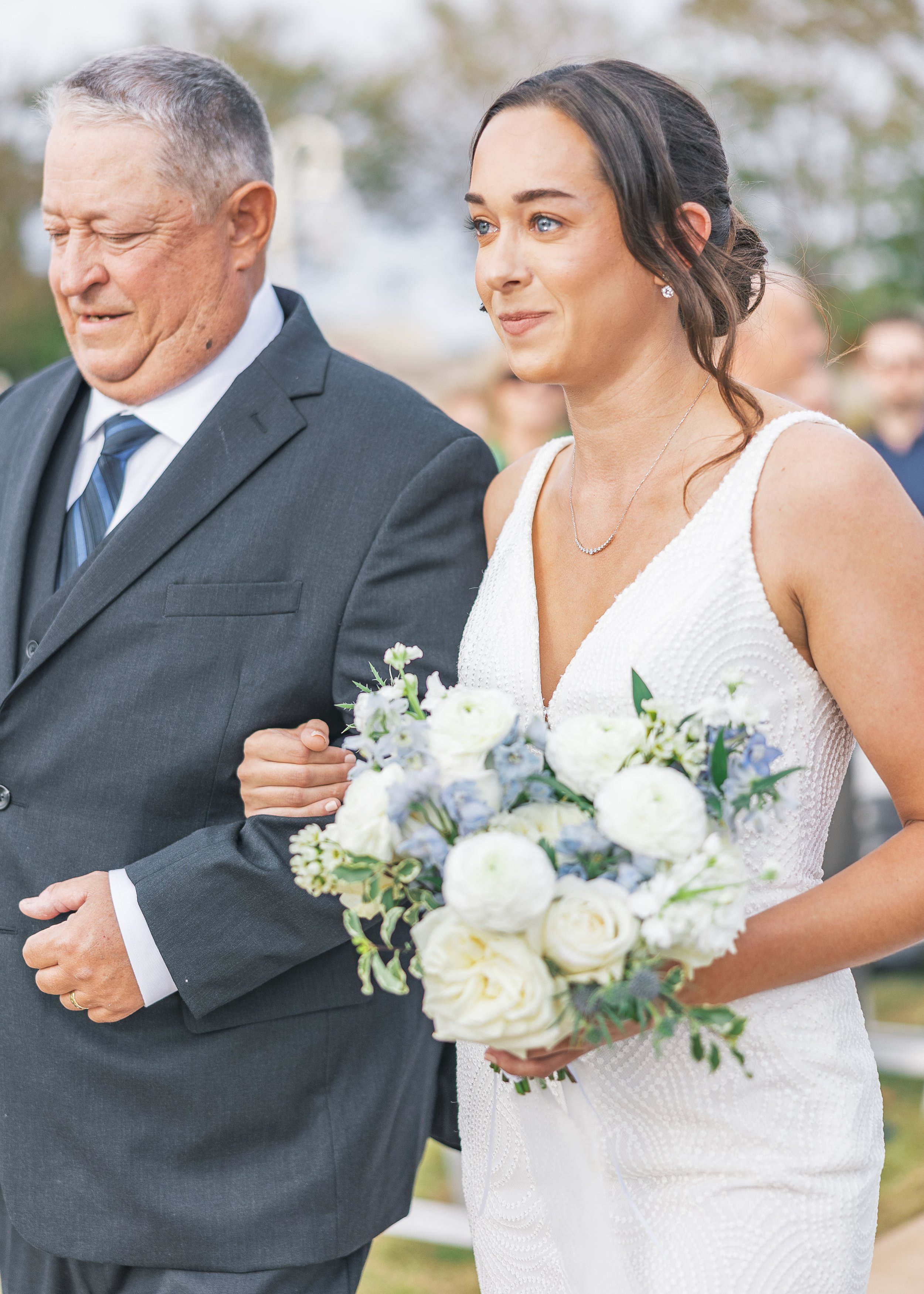 Bride is teary-eyed, walking down the aisle by her dad at her Orlando Florida wedding