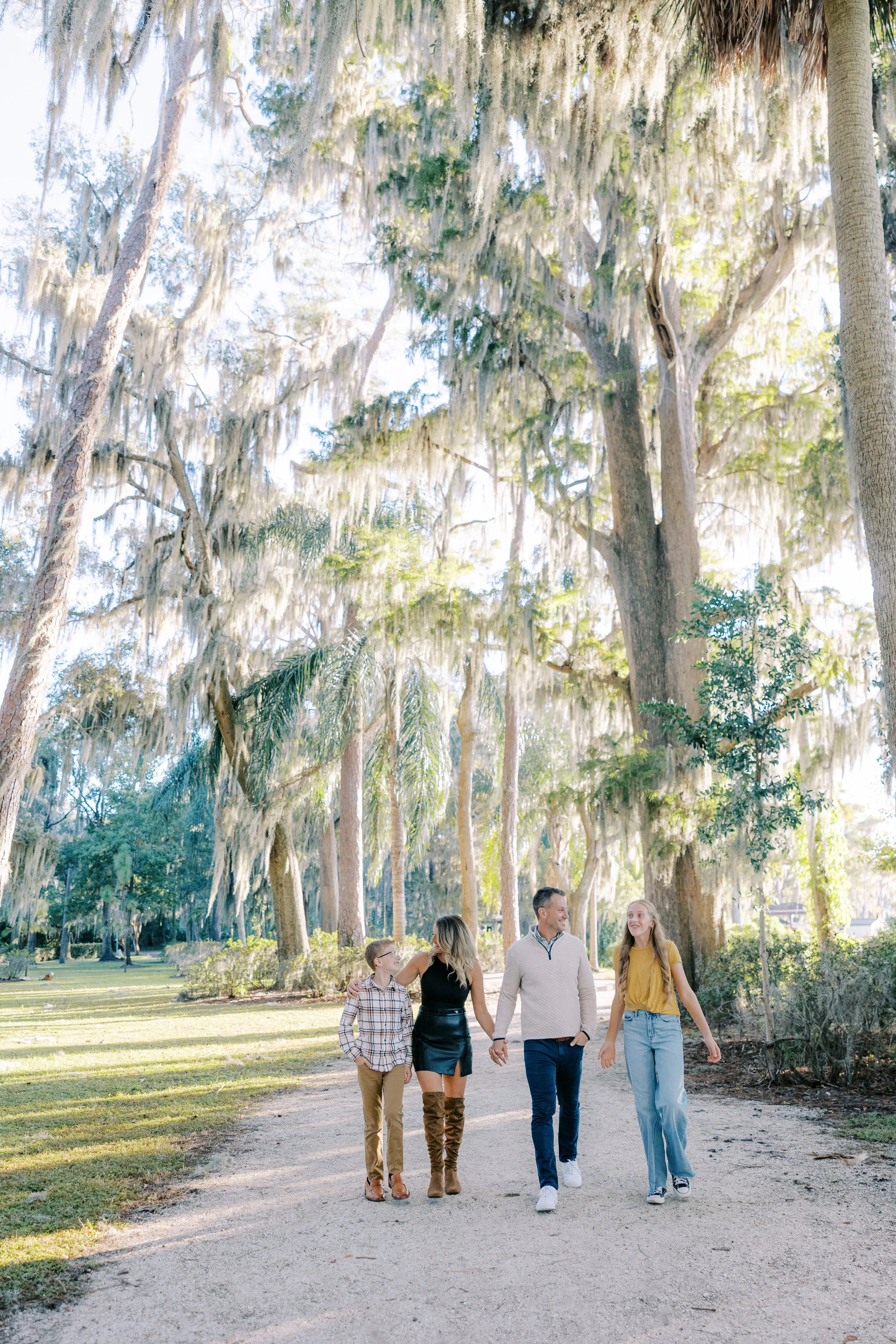 Family walks together for family photo shoot at Kraft Azalea Garden in Winter Park Florida