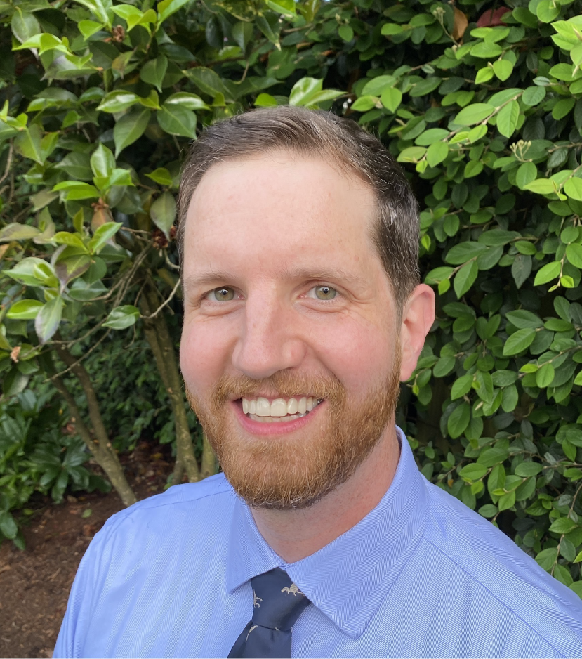 Photo of Brad, the ASL clip artist, at his home. There is a camellia in the background.