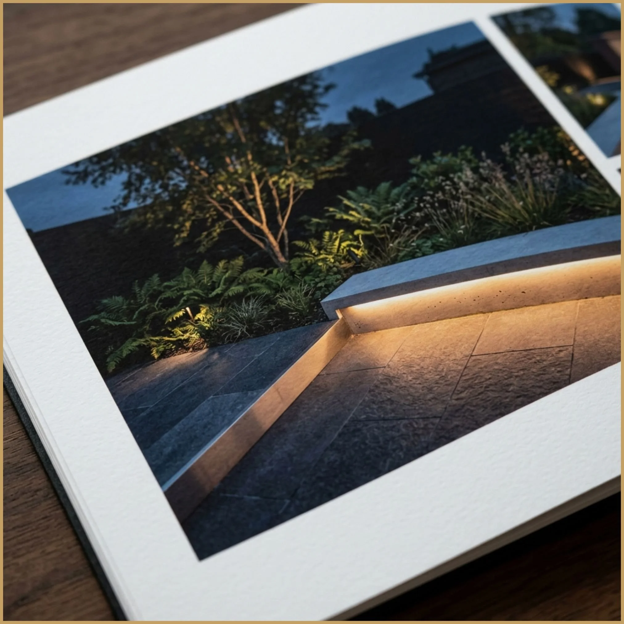 An open A3 presentation displaying a warm garden dusk visual sheet next to a structured technical page with architectural site plans.