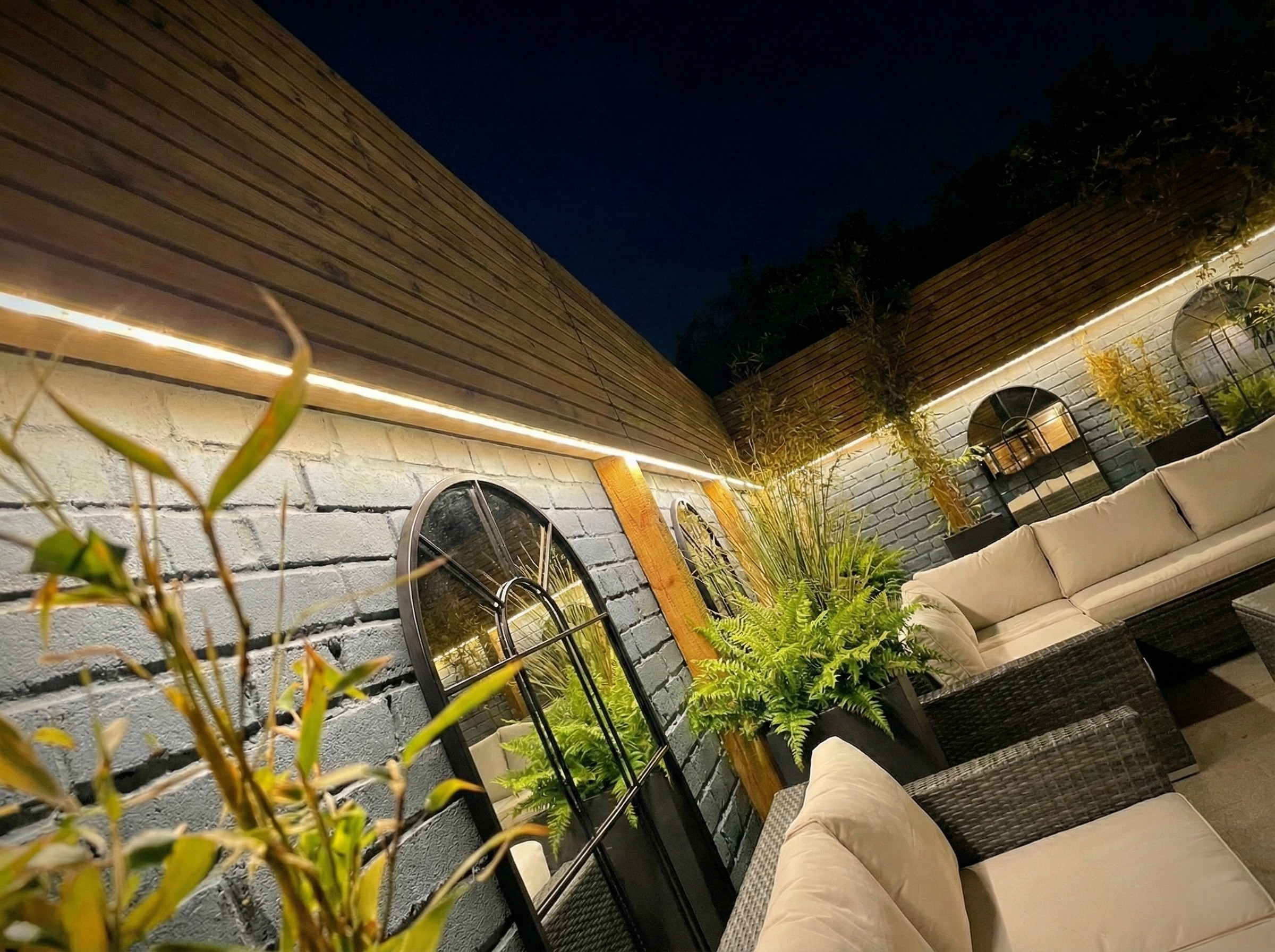 night-garden-lighting-design-led-strip-lights-painted-brick-wall.png