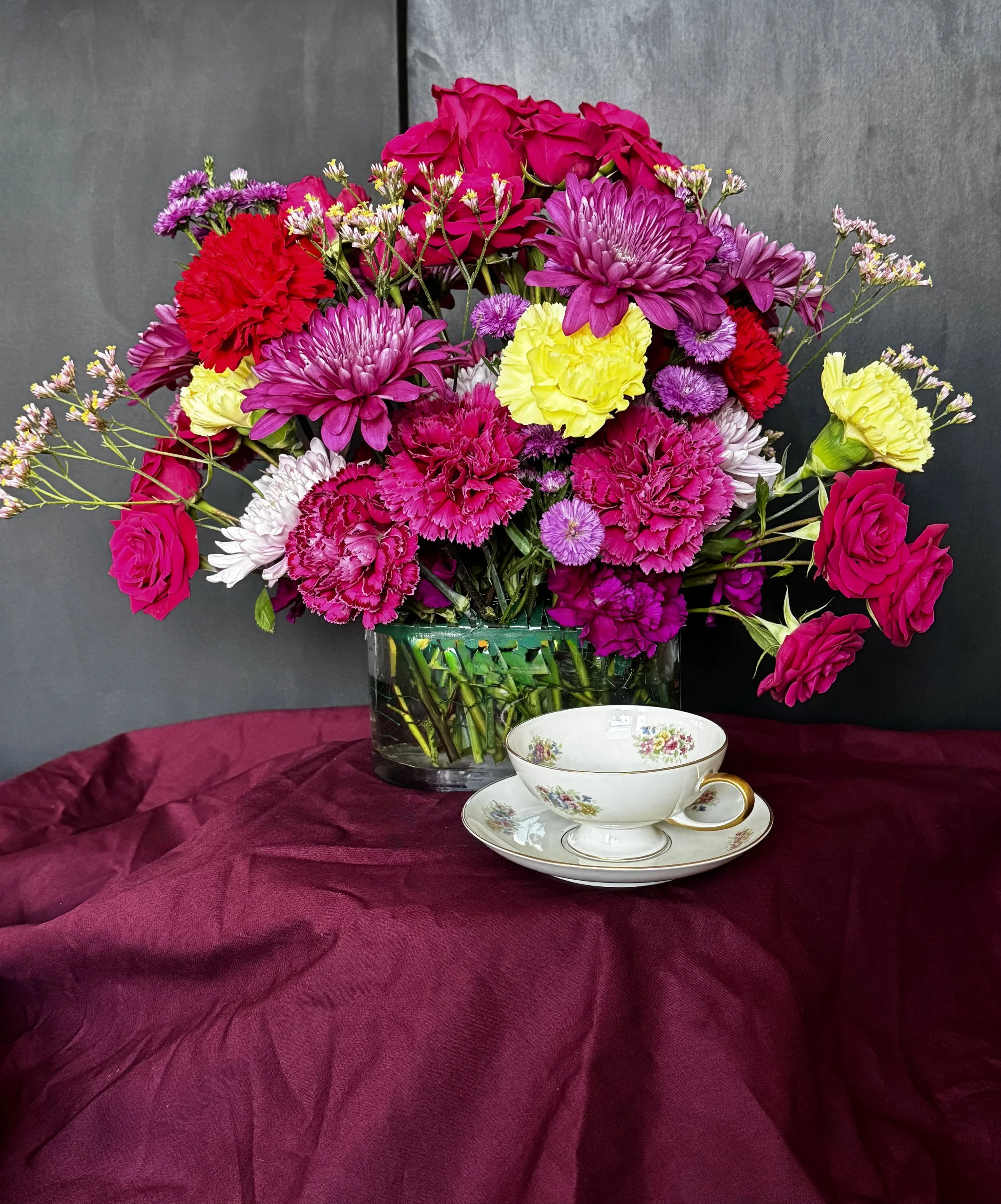 Lounge-Ready Jewel-Tone Arrangement — a vibrant mix of magenta, plum, and buttercream blooms styled for elevated hospitality spaces.