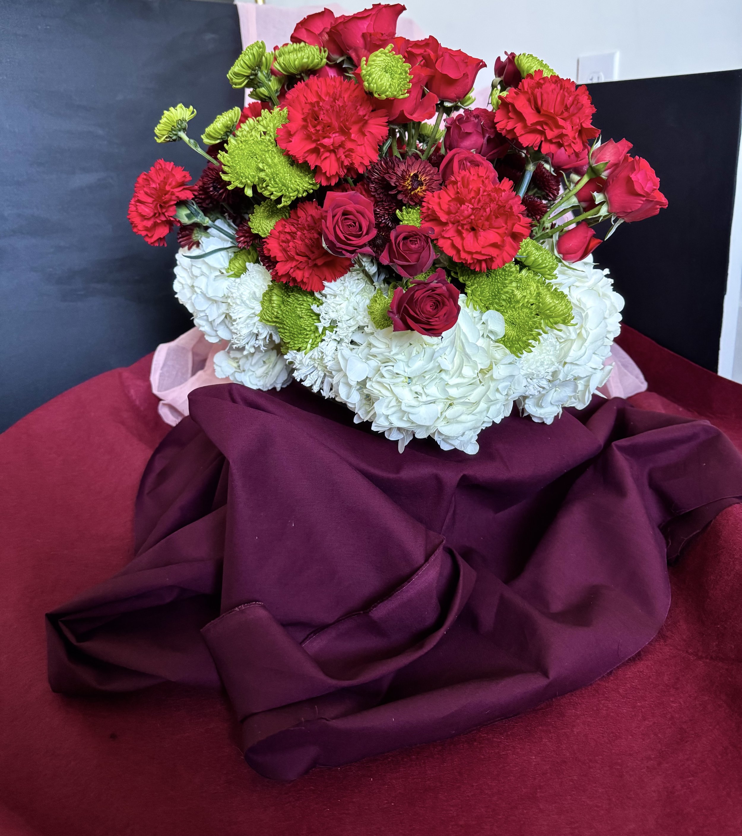 Holiday Statement Centerpiece — lush red, white, and fresh green blooms designed to elevate lobbies, lounges, and seasonal gatherings.