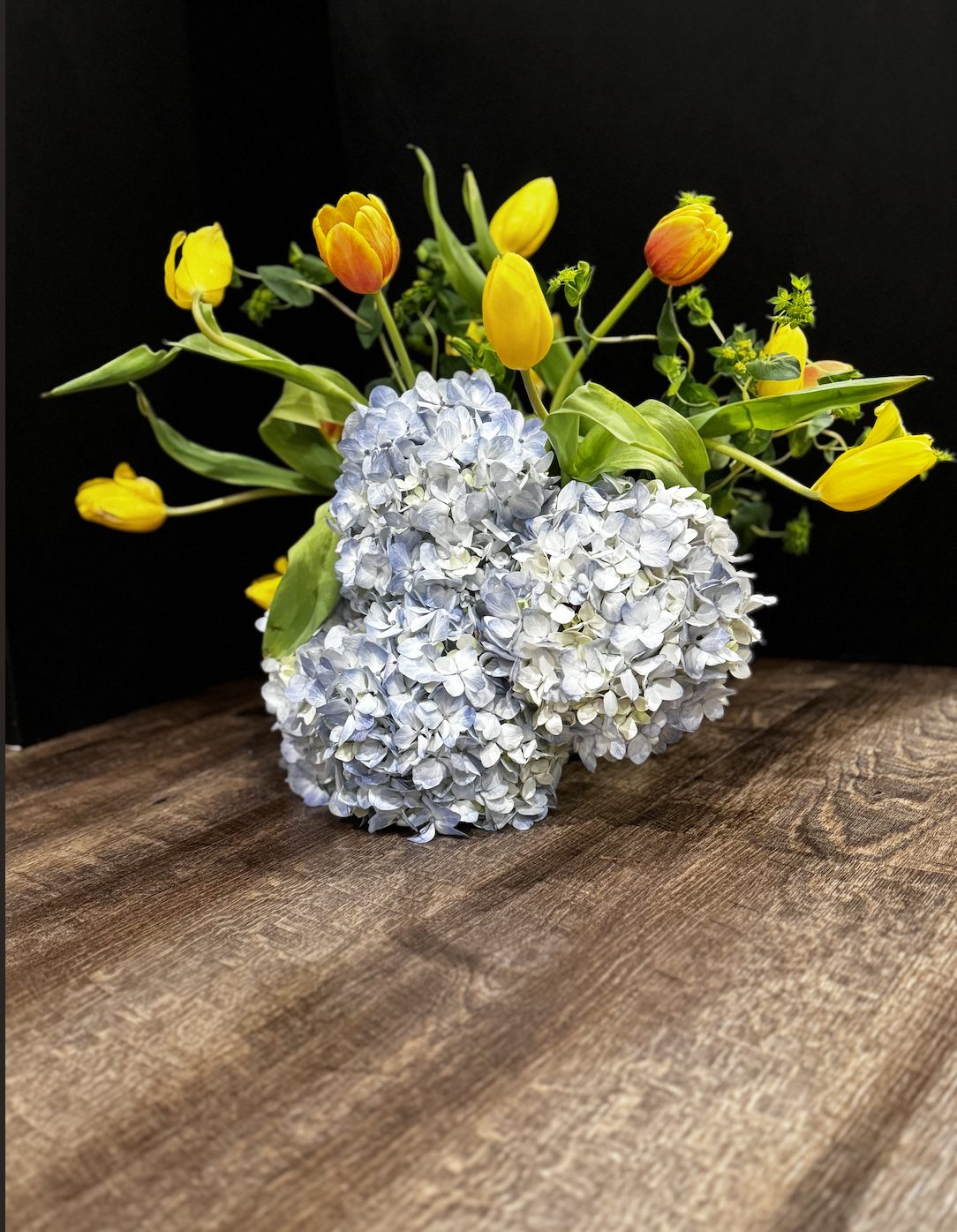 Low-Profile Table Moment — blue hydrangea with yellow tulips, designed for bars, host stands, and dining tables without blocking sightlines.